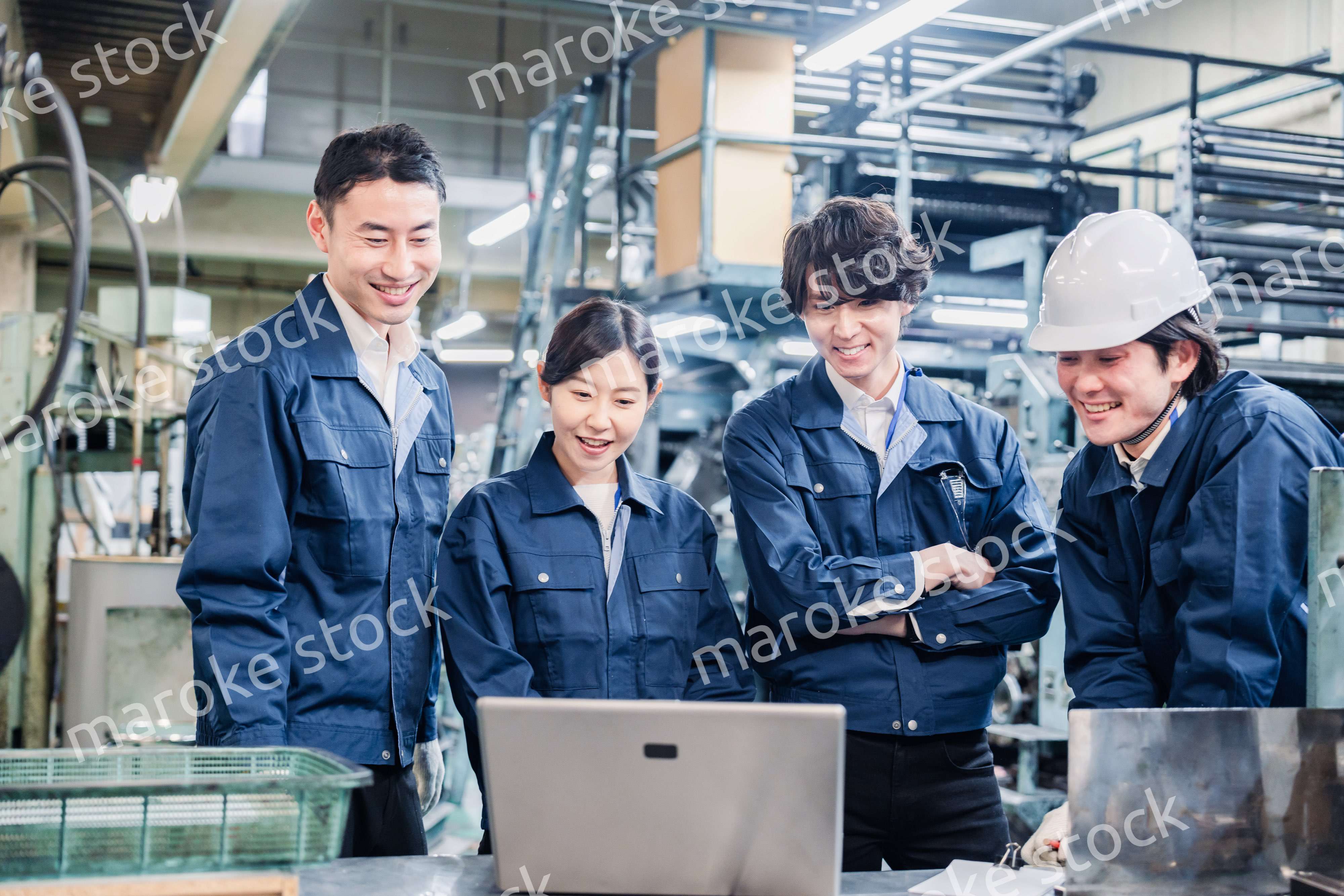 パソコンを見ながら議論をする工場スタッフ