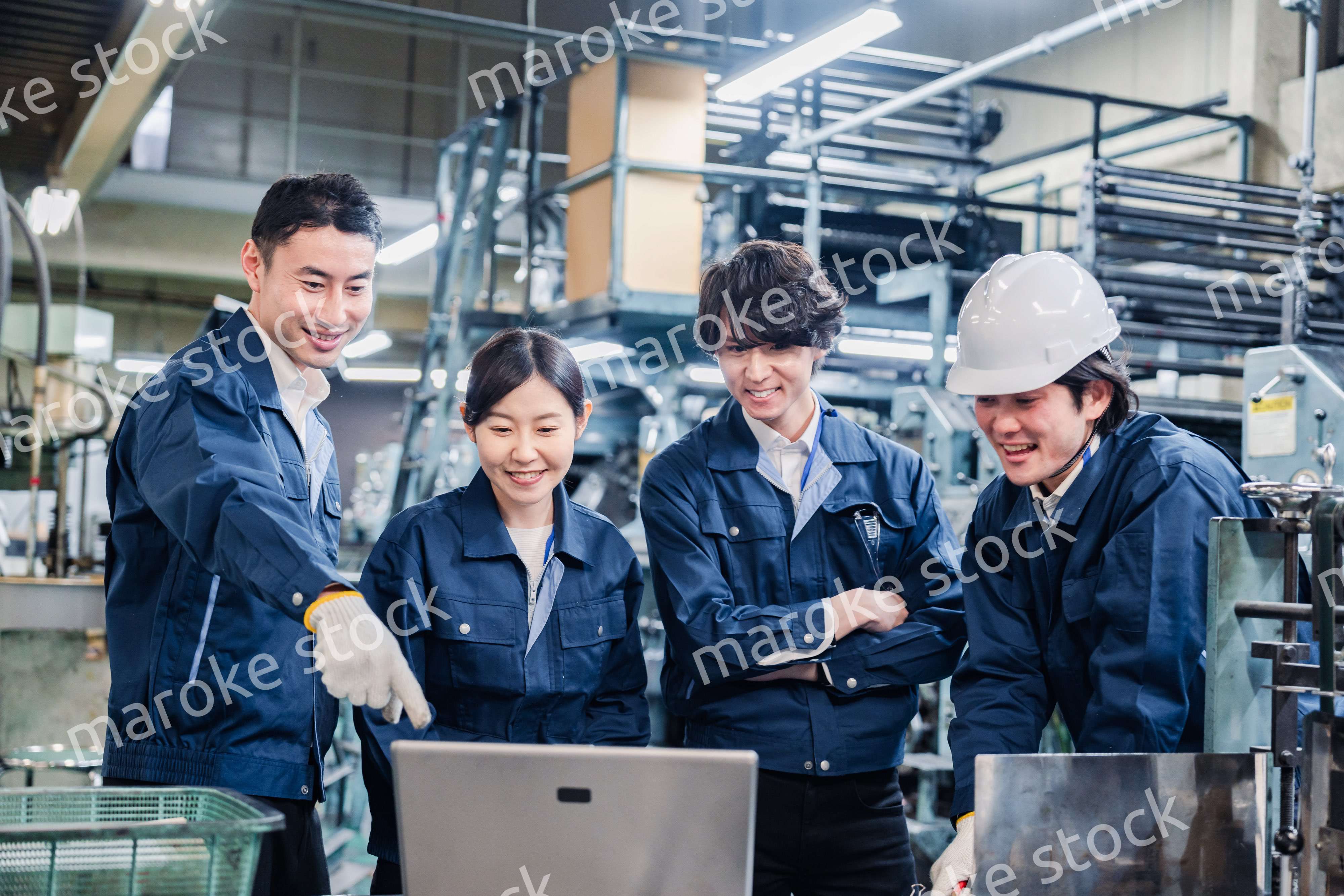 パソコンを見ながら議論をする工場スタッフ