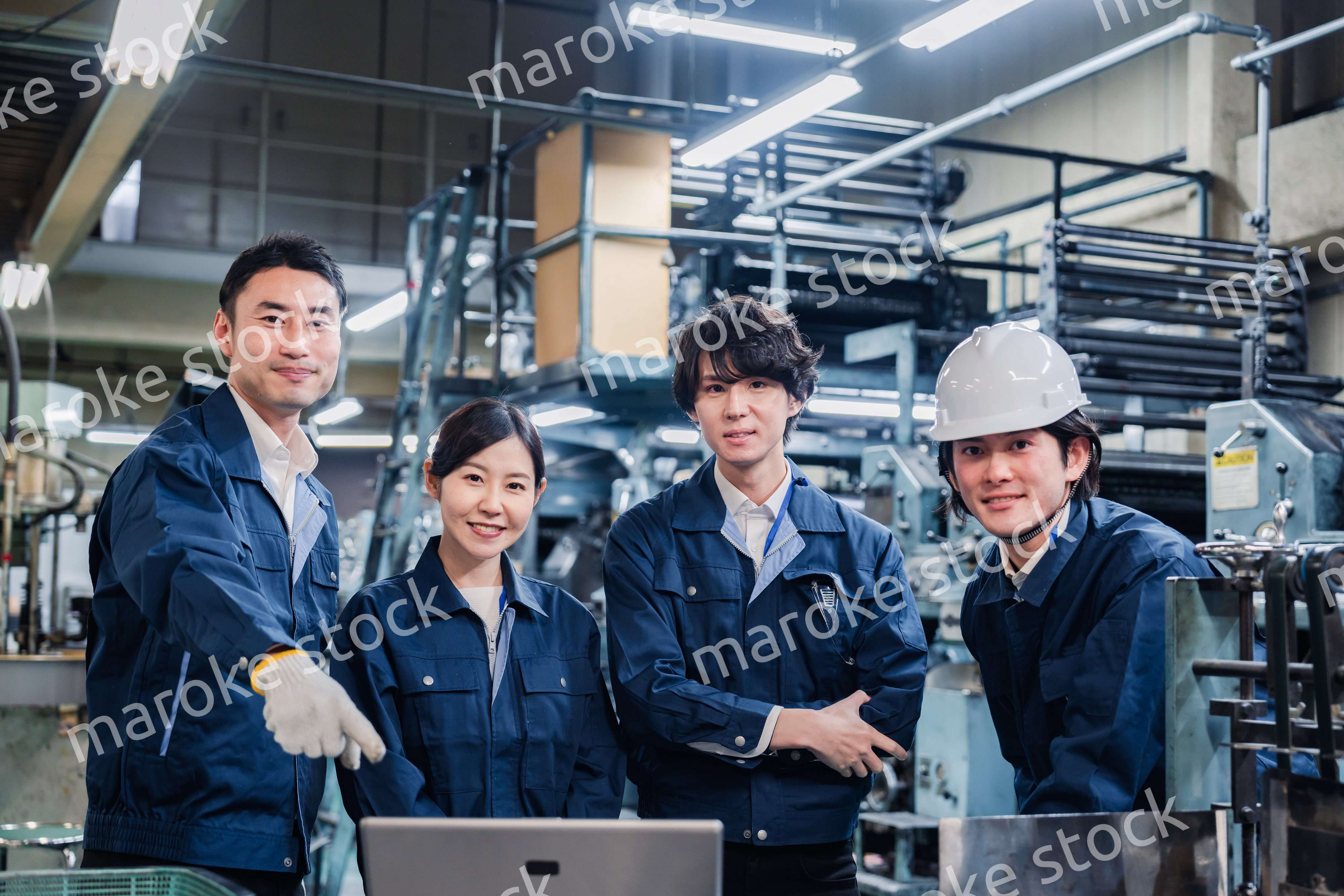 パソコンを見ながら議論をする工場スタッフ