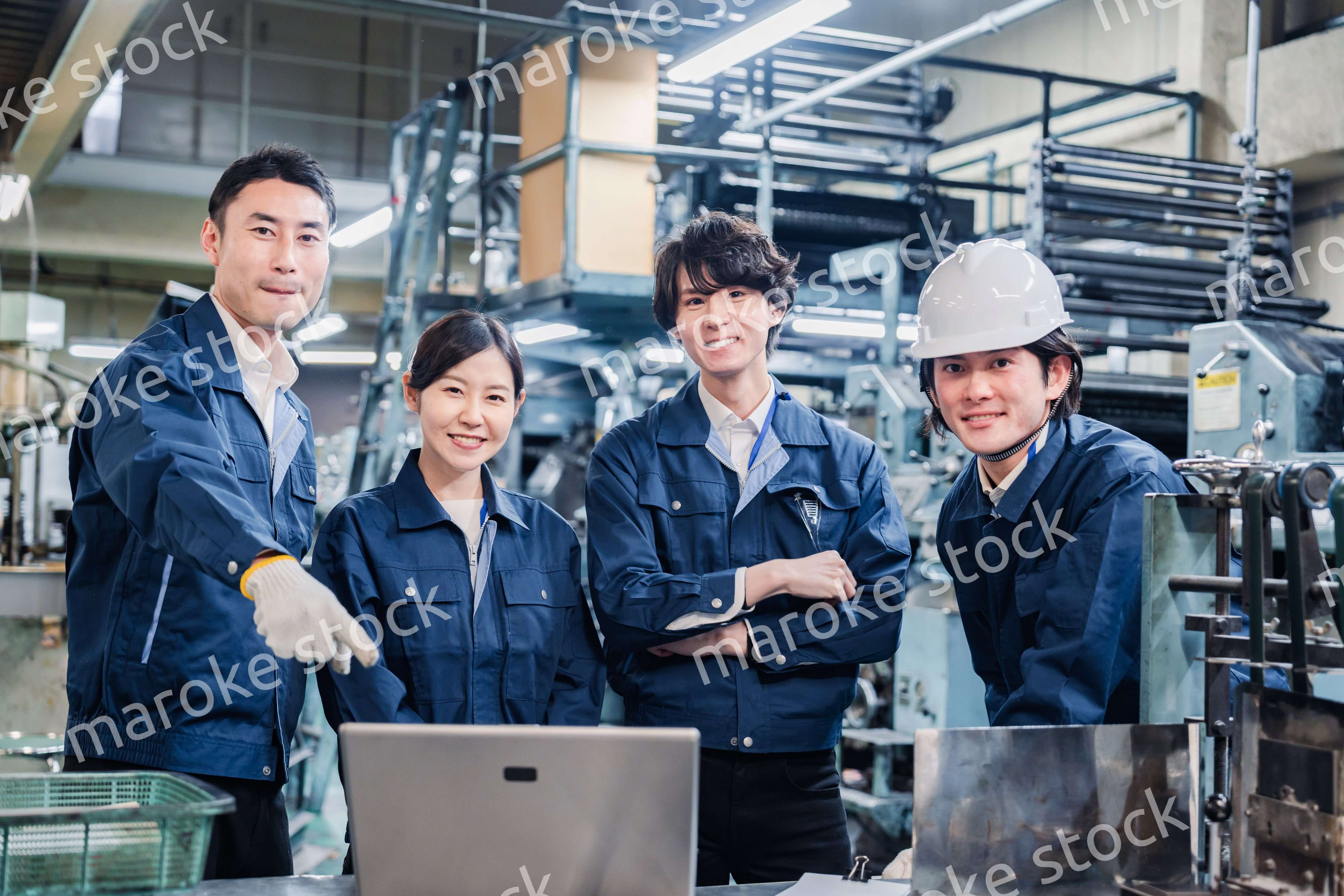 パソコンを見ながら議論をする工場スタッフ