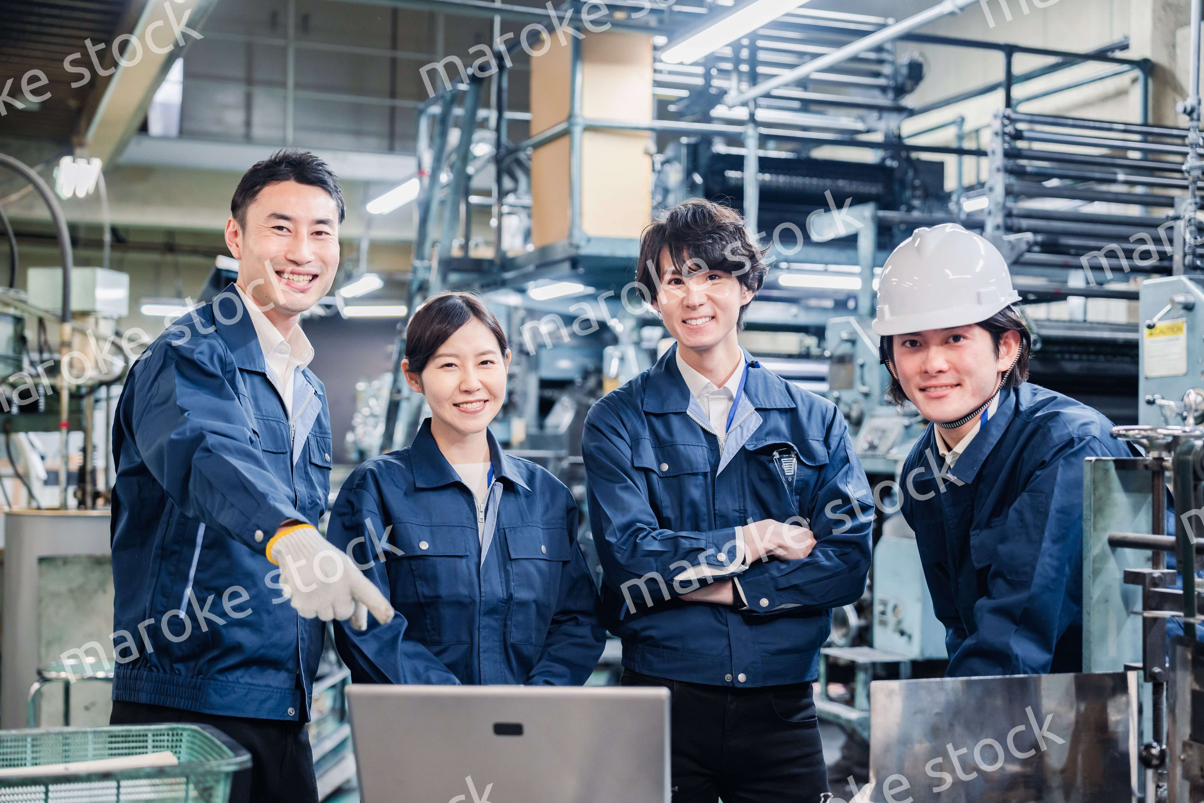 パソコンを見ながら議論をする工場スタッフ