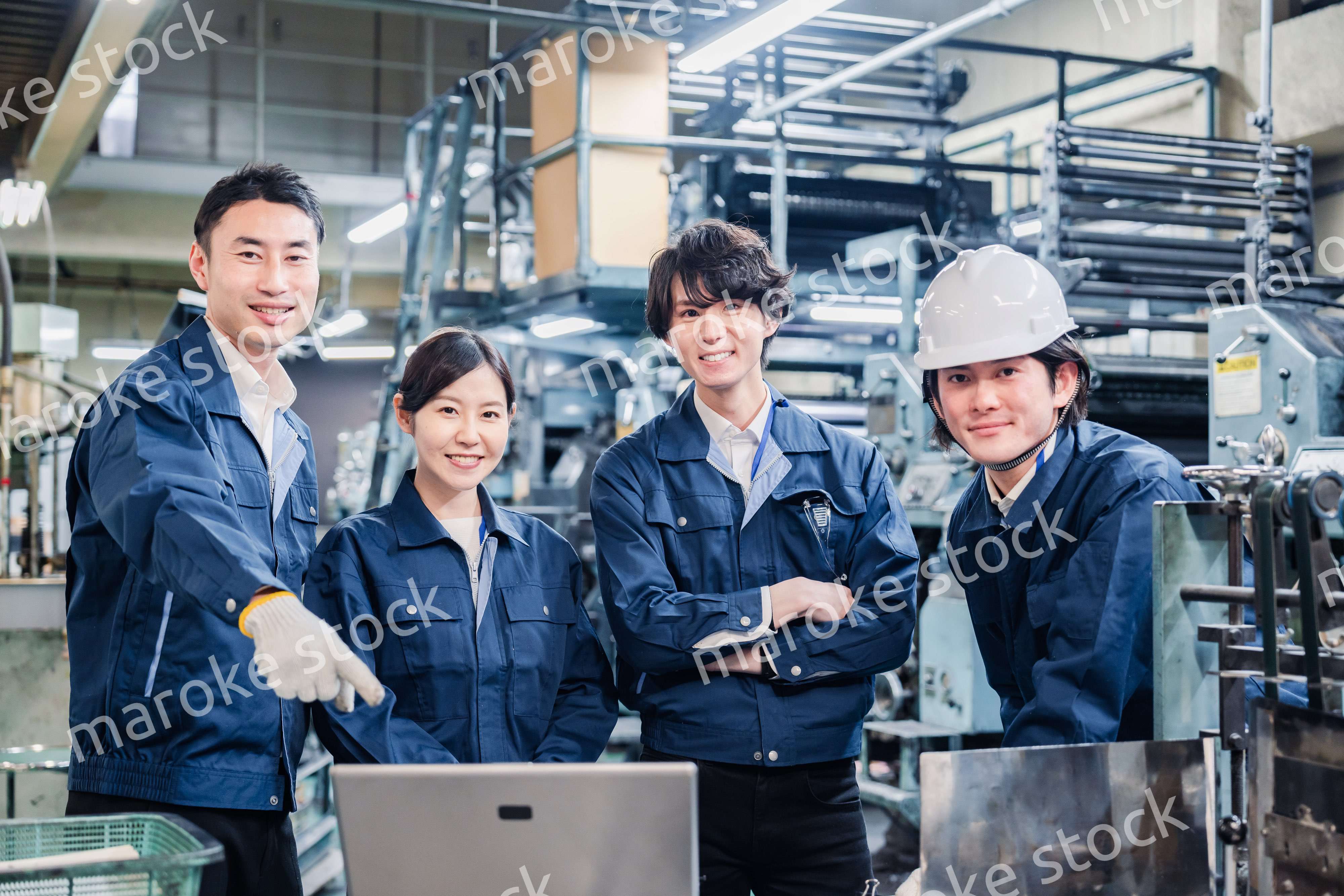 パソコンを見ながら議論をする工場スタッフ