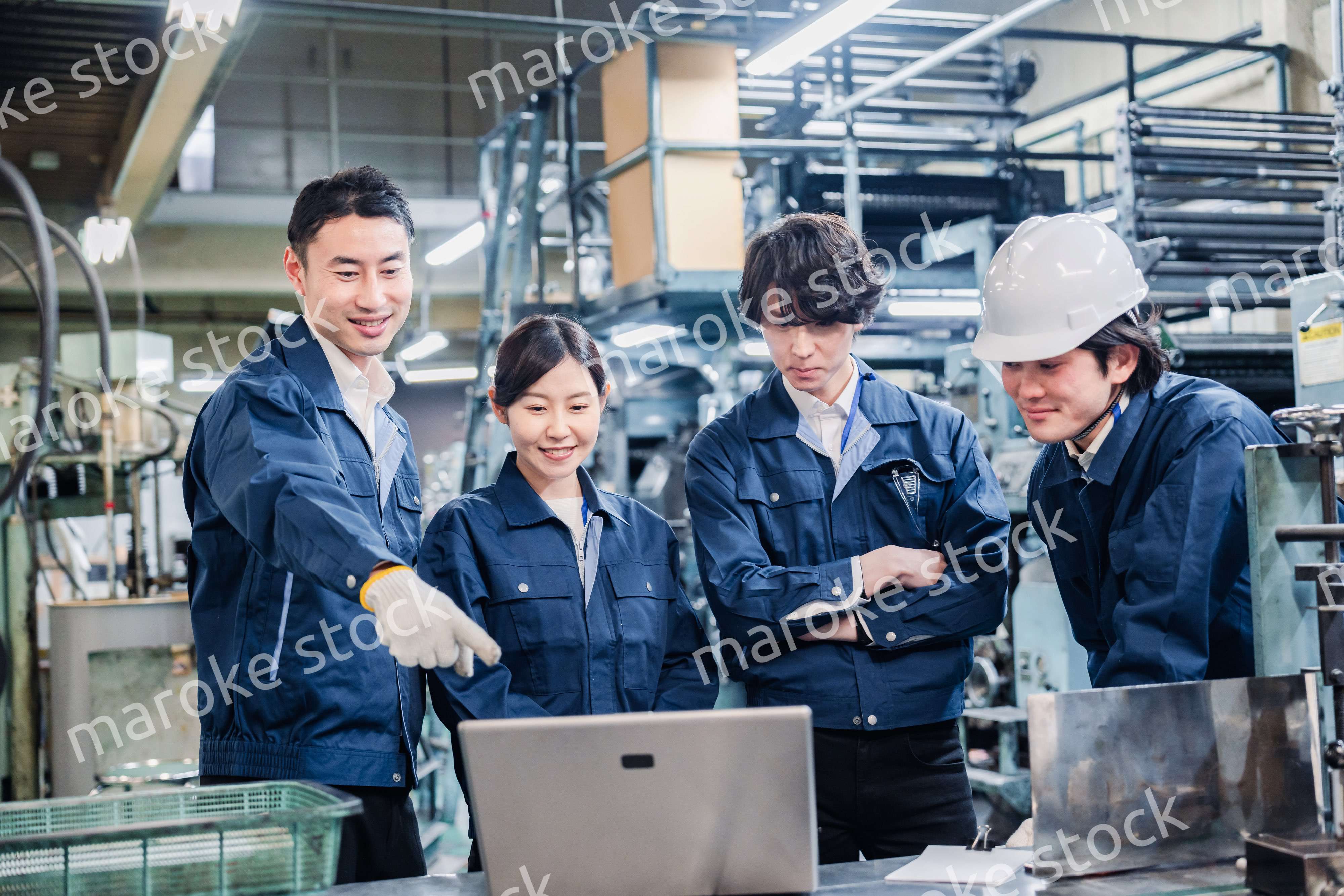 パソコンを見ながら議論をする工場スタッフ