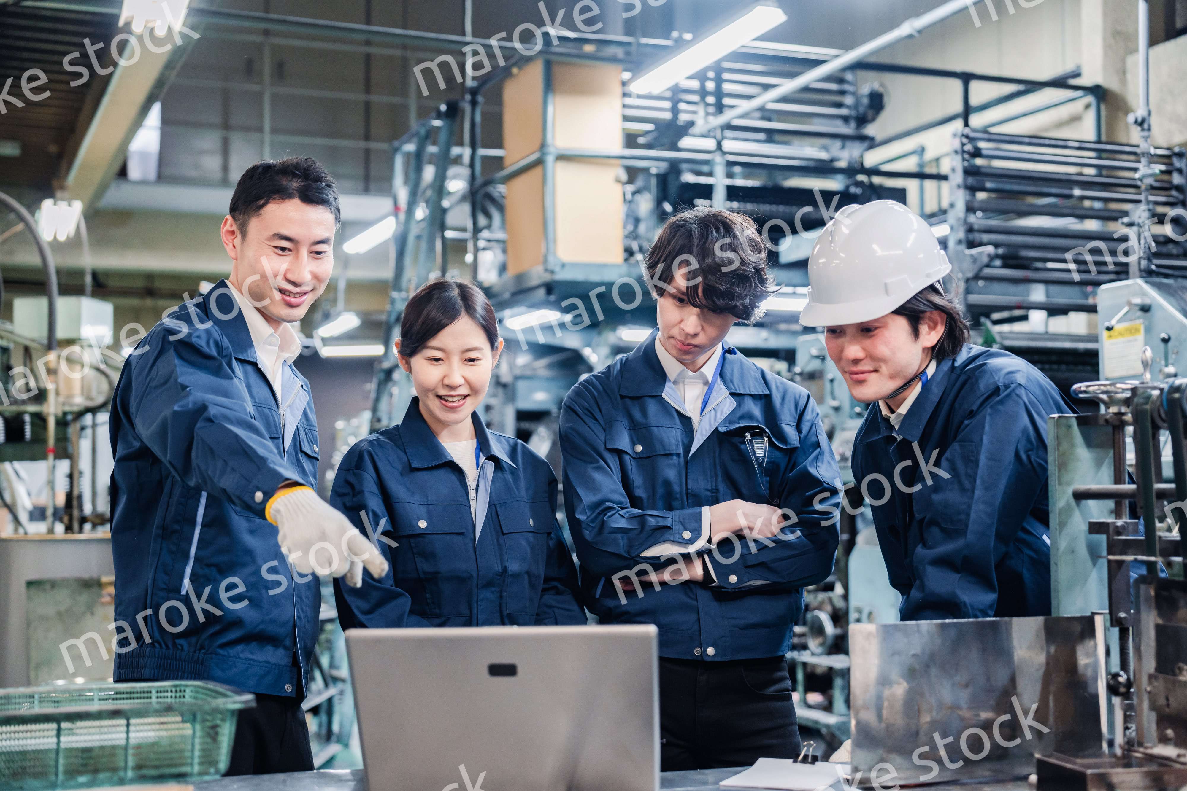 パソコンを見ながら議論をする工場スタッフ