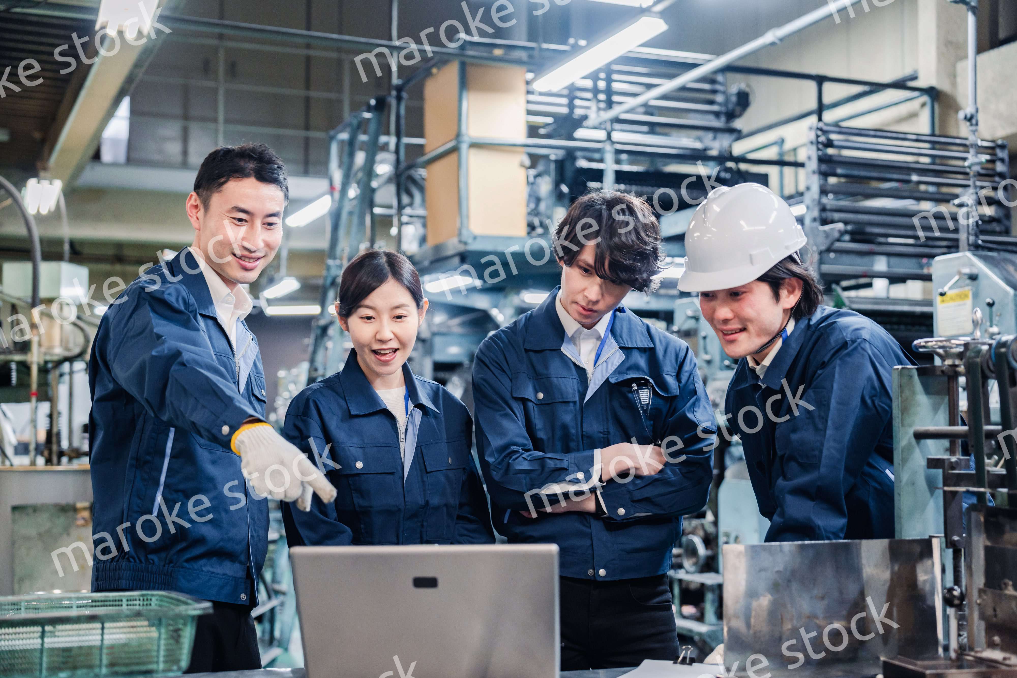 パソコンを見ながら議論をする工場スタッフ