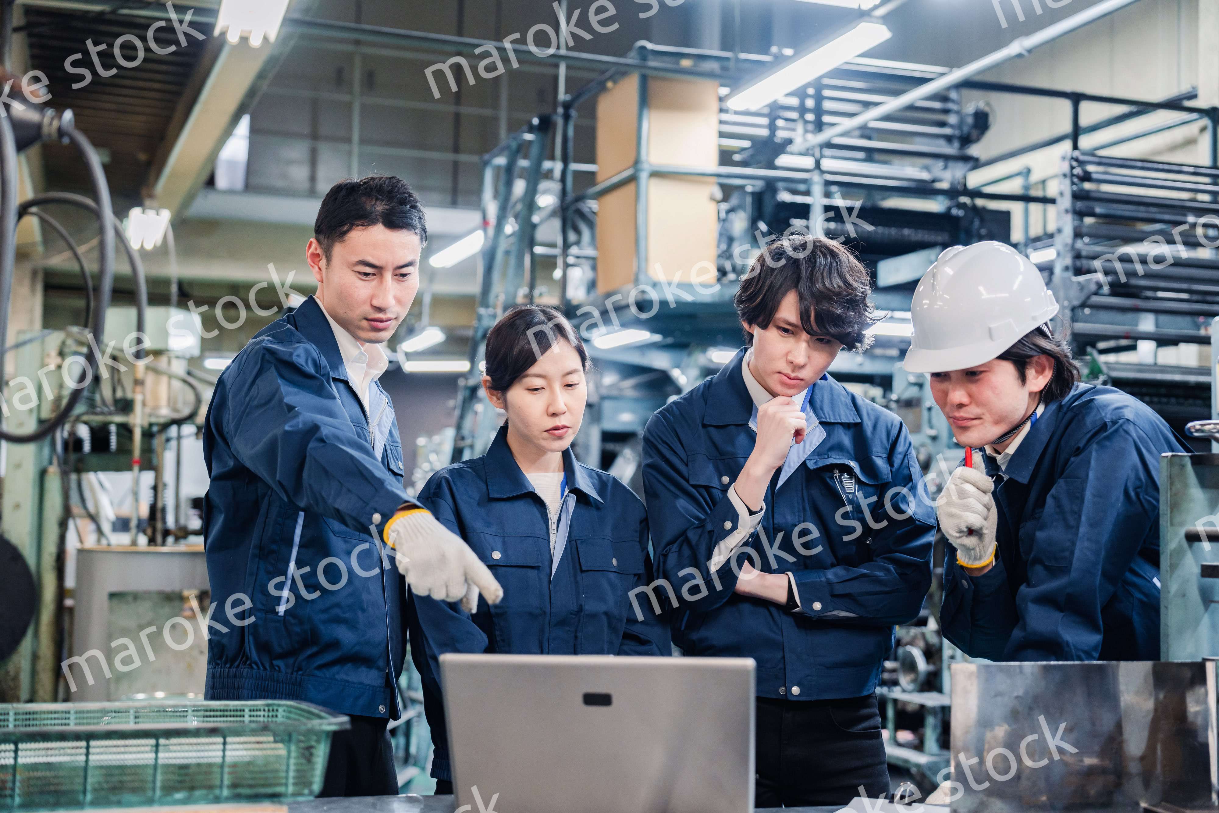パソコンを見ながら議論をする工場スタッフ