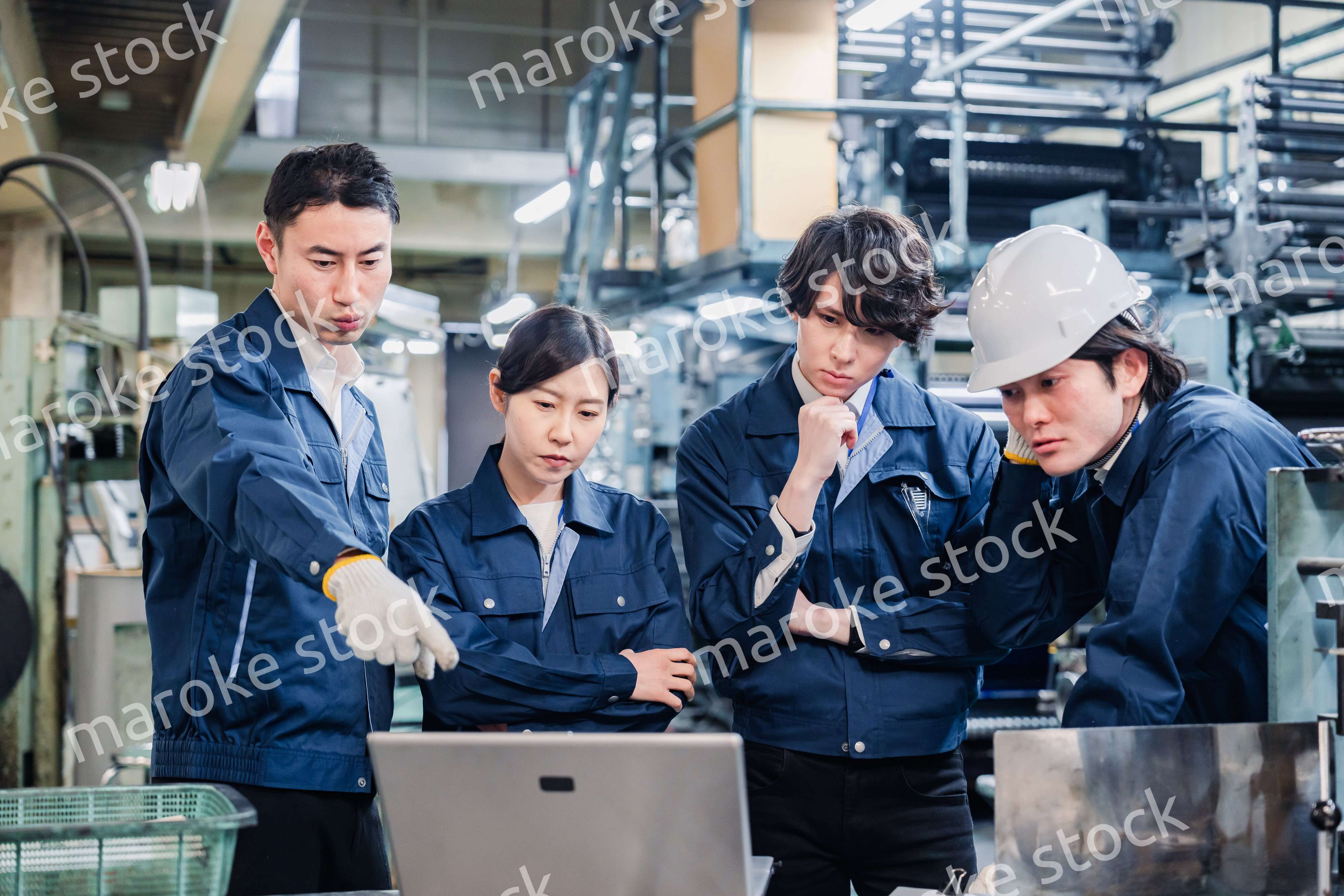 パソコンを見ながら議論をする工場スタッフ