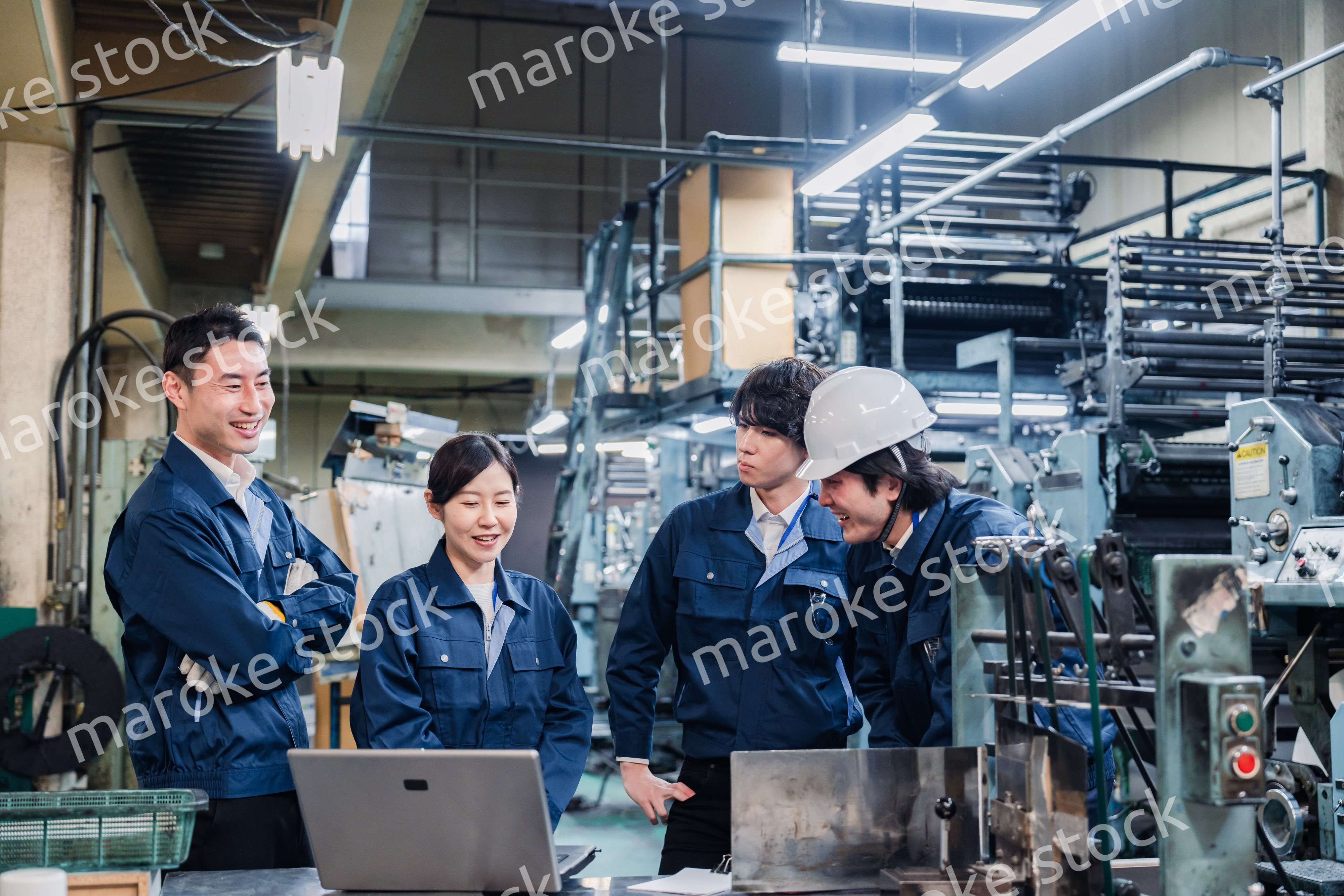 パソコンを見ながら議論をする工場スタッフ