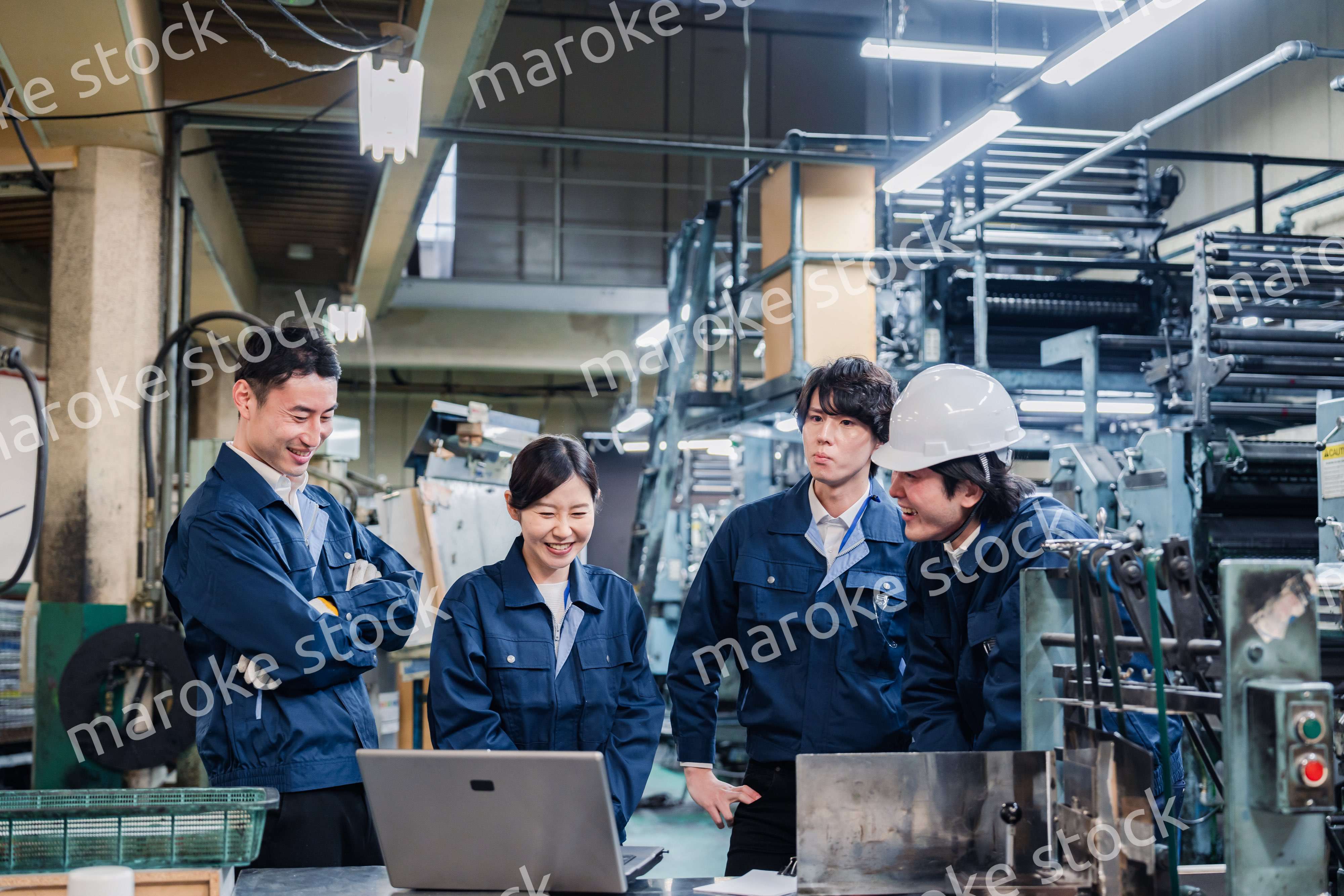 パソコンを見ながら議論をする工場スタッフ