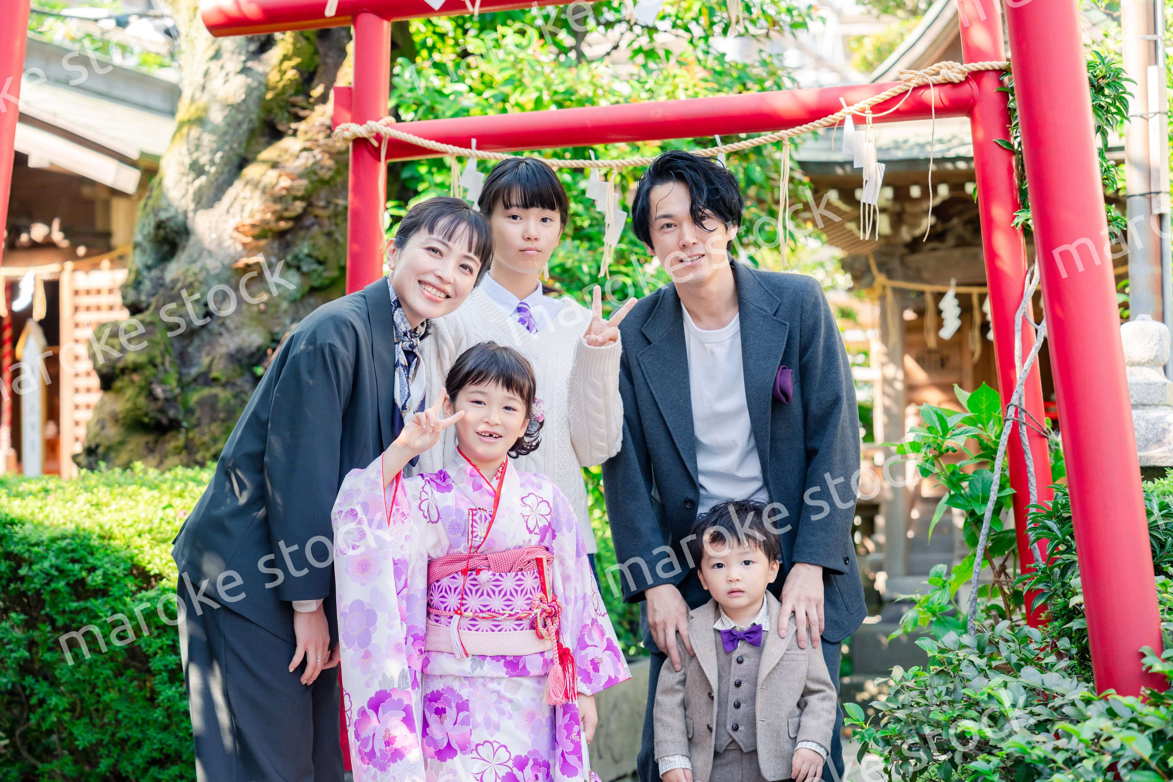 兄弟姉妹揃って神社で七五三のお祝いをする家族