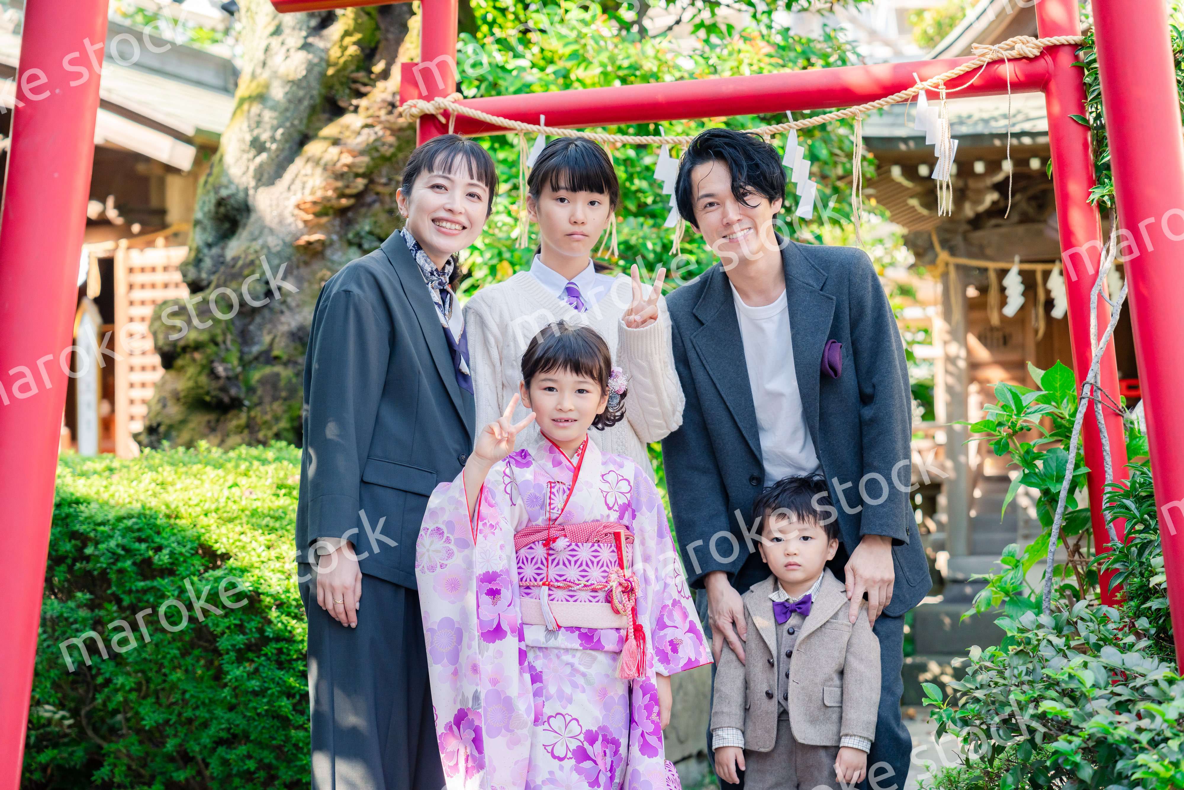 兄弟姉妹揃って神社で七五三のお祝いをする家族