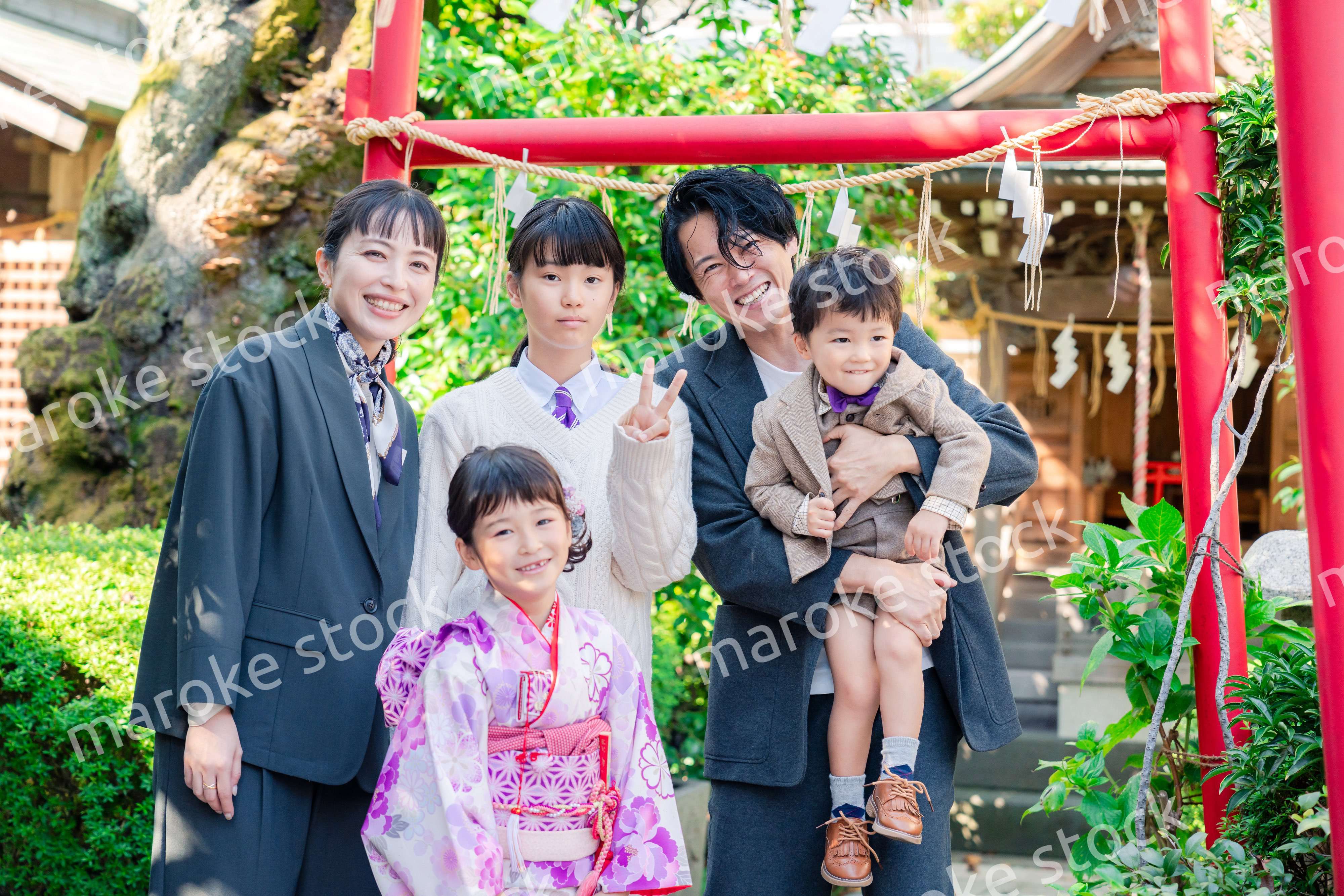 兄弟姉妹揃って神社で七五三のお祝いをする家族