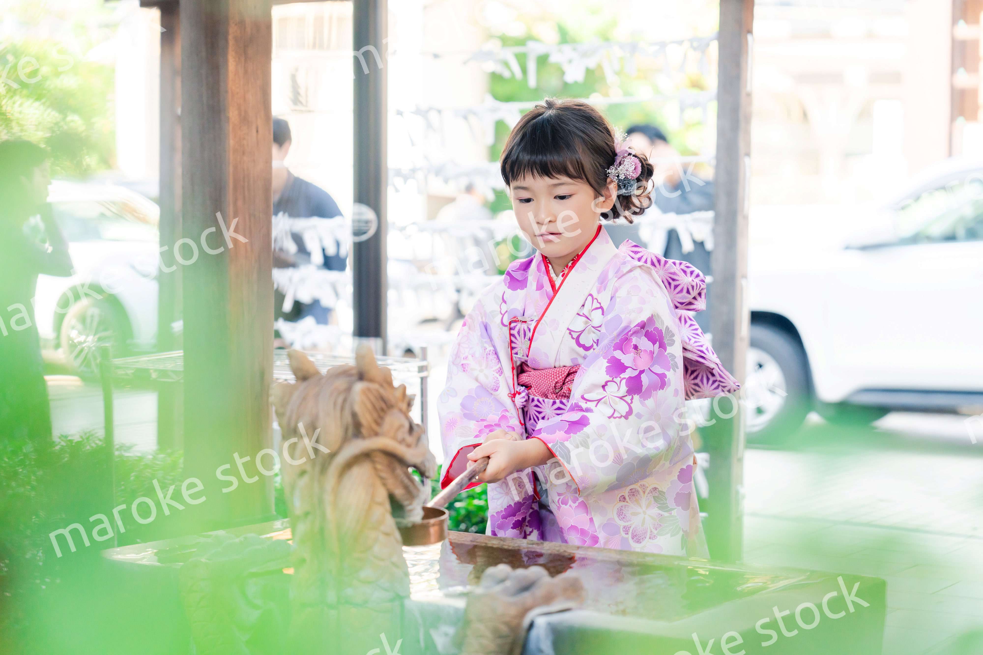 神社の手水舎で手を清める七五三の女の子
