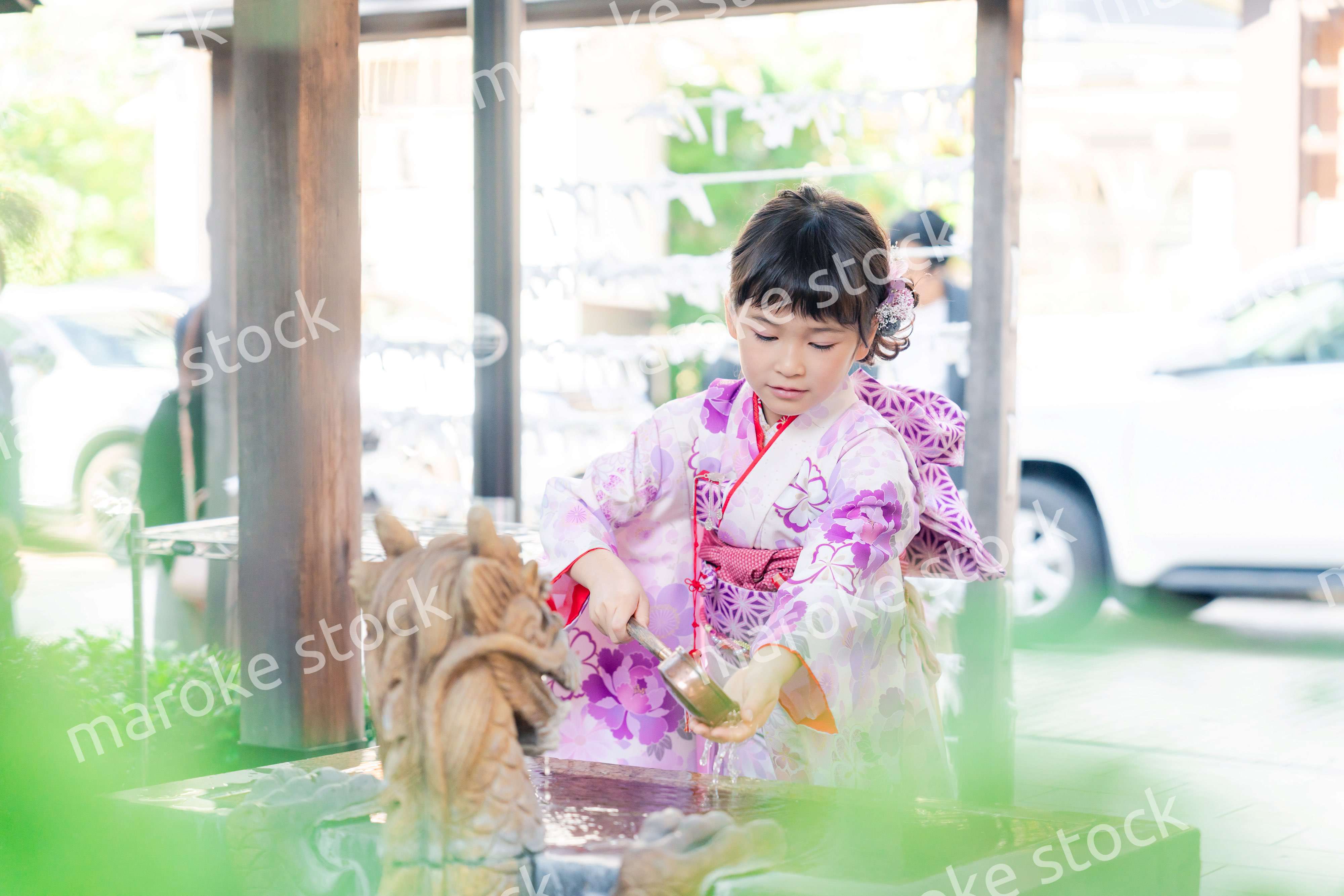 神社の手水舎で手を清める七五三の女の子