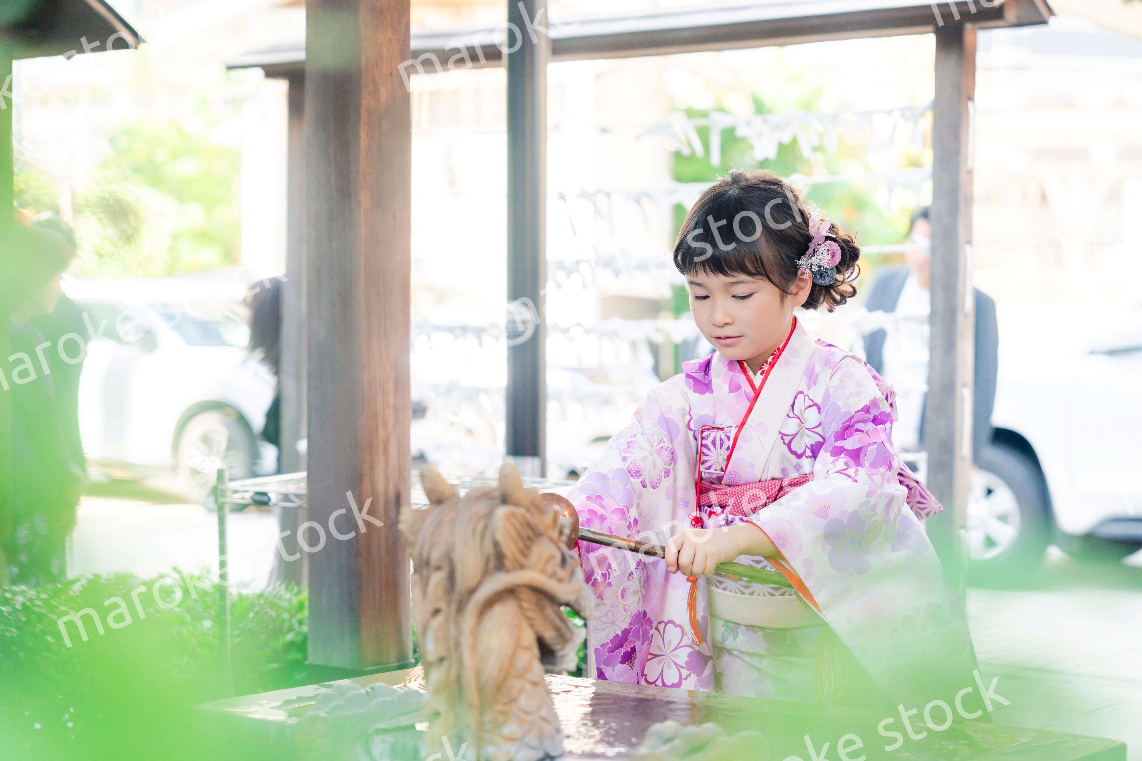 神社の手水舎で手を清める七五三の女の子
