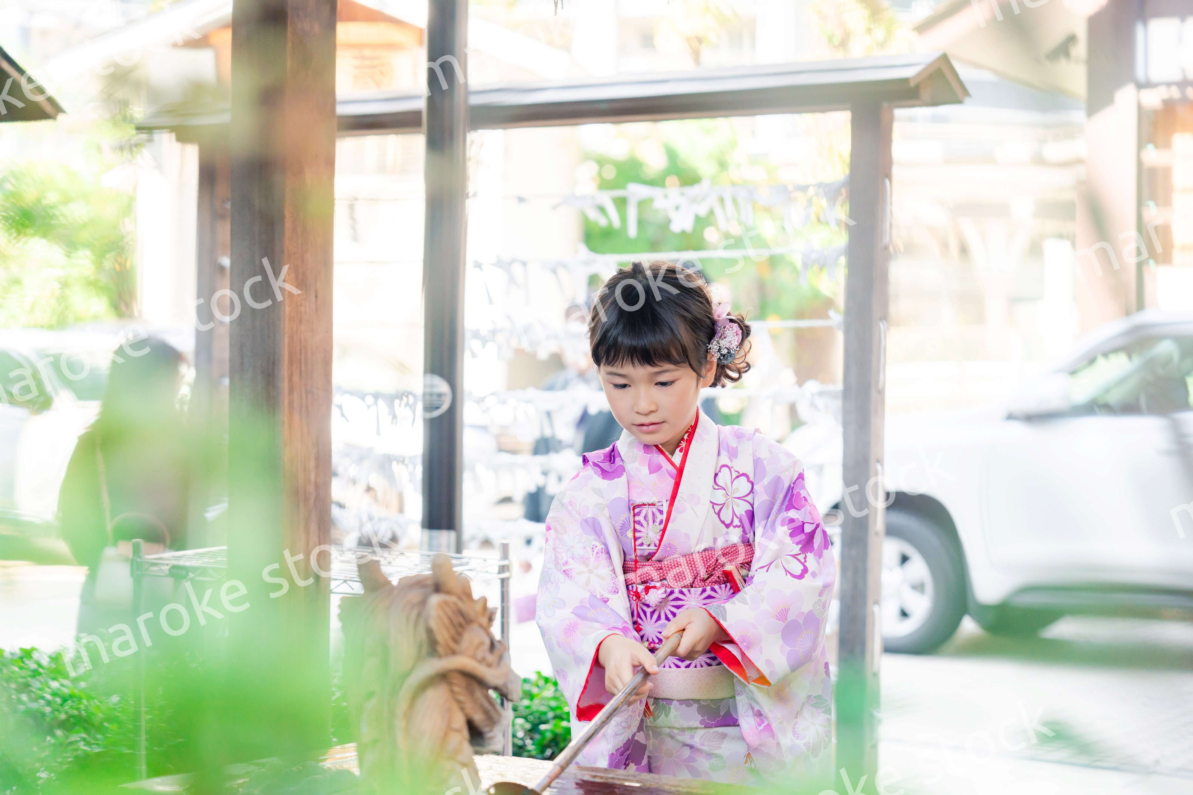 神社の手水舎で手を清める七五三の女の子