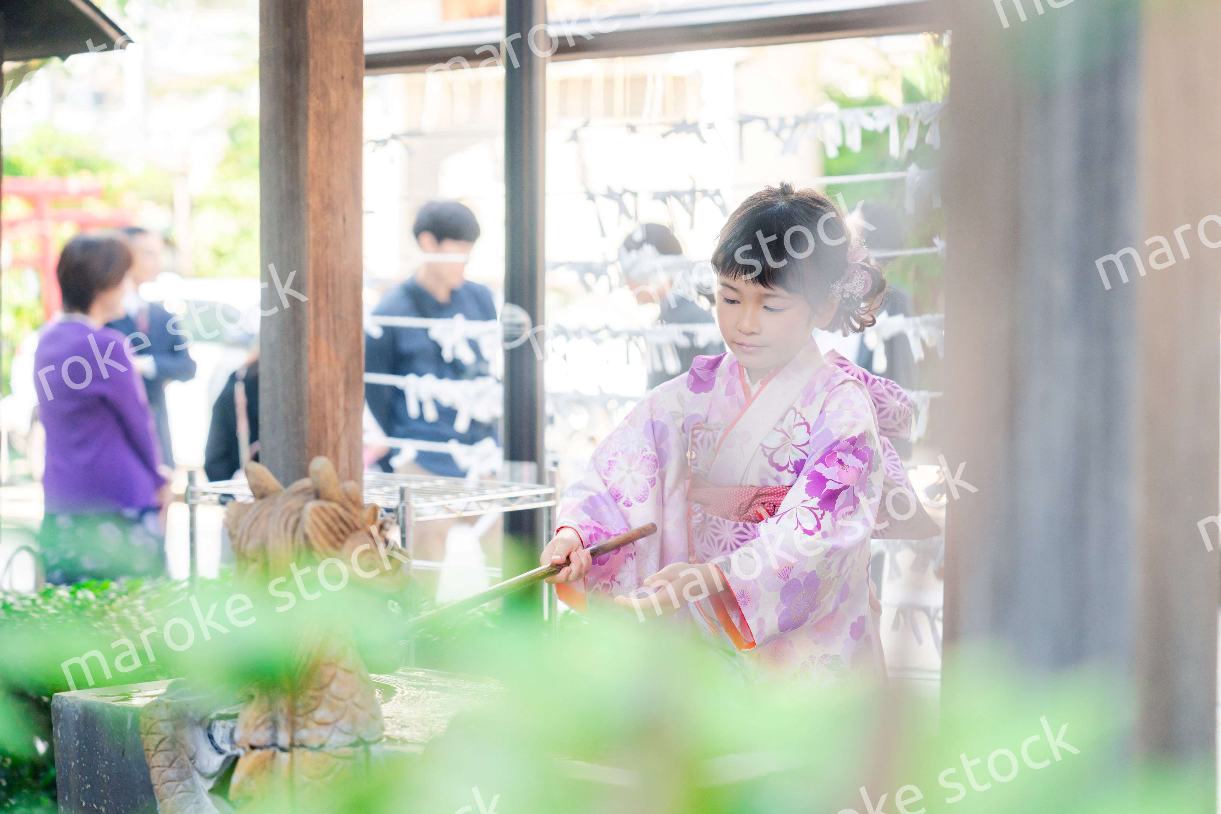 神社の手水舎で手を清める七五三の女の子
