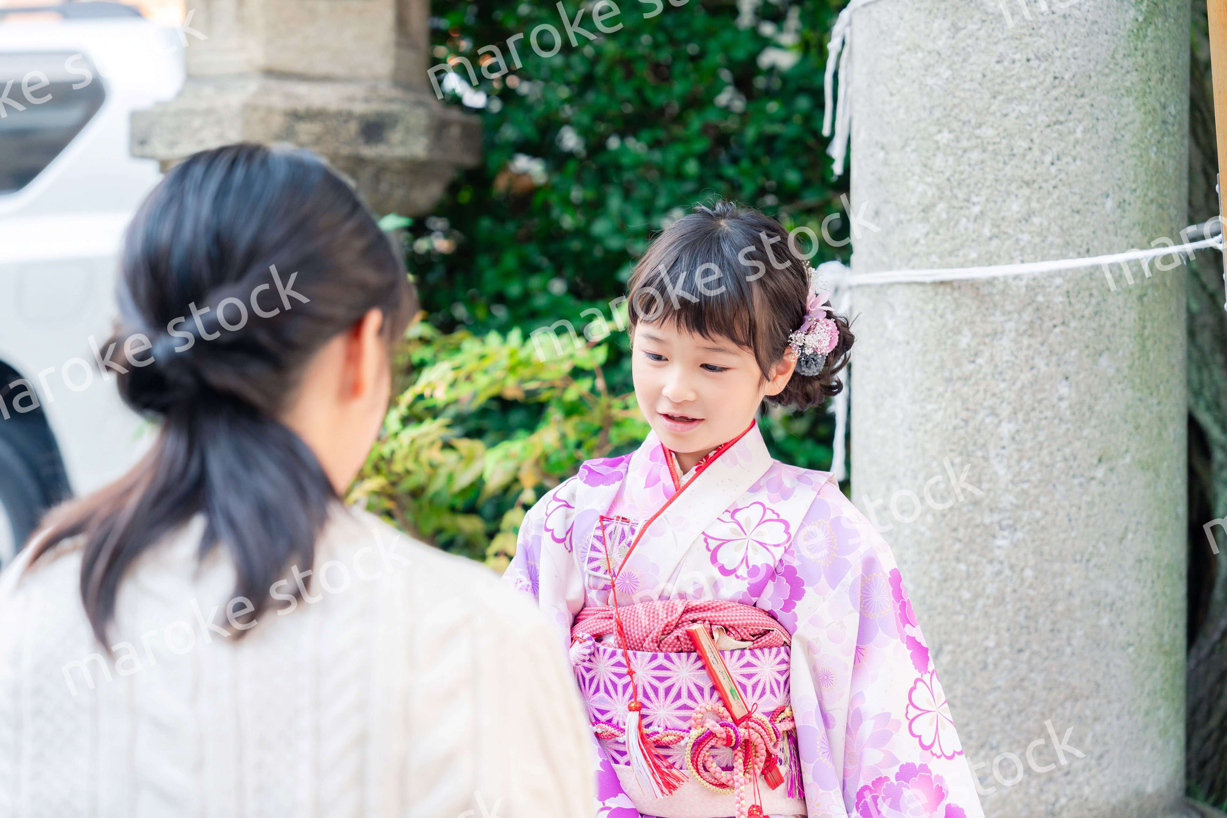七五三をお祝いする子どもと服を整えるお母さん