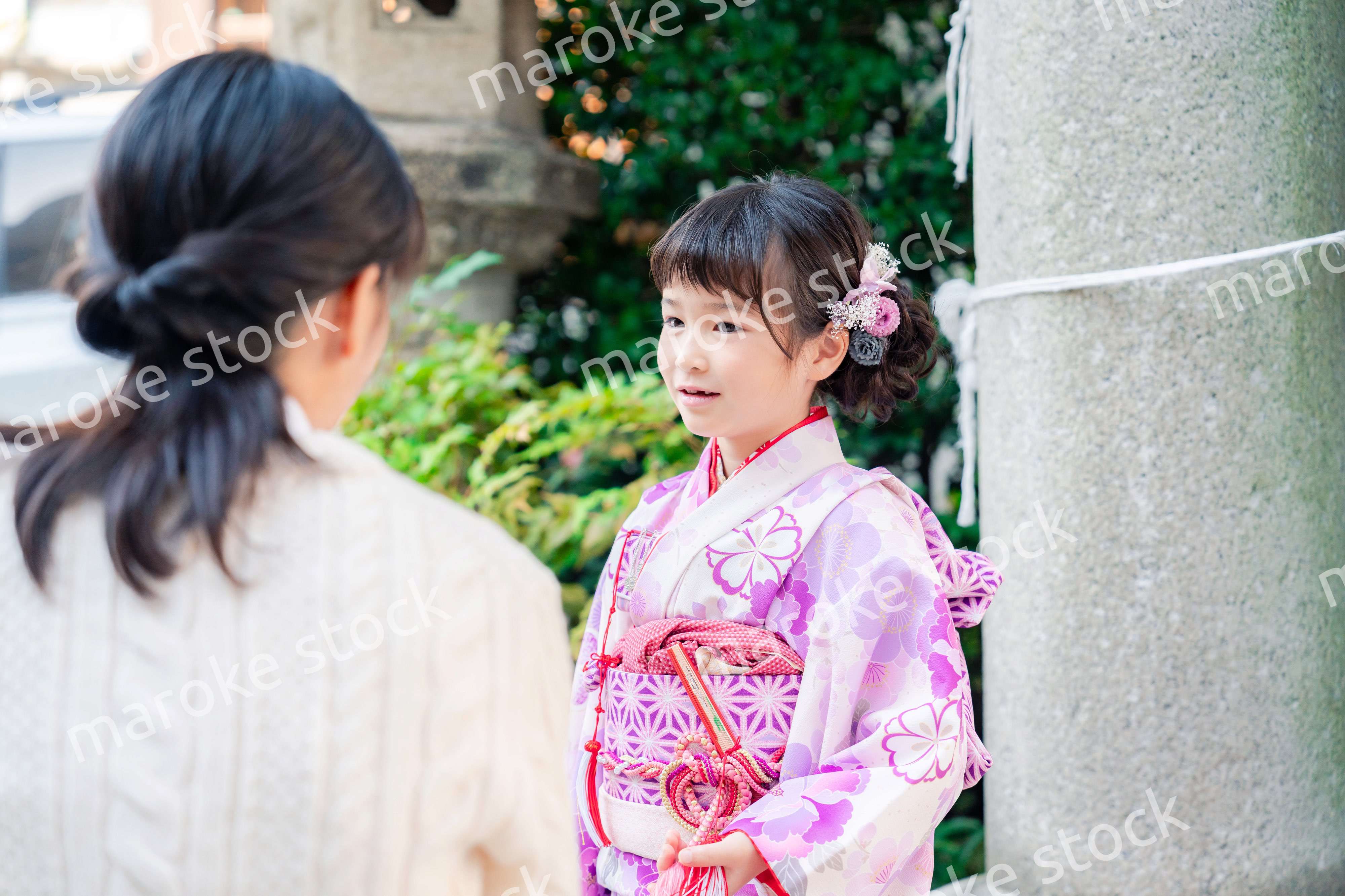 七五三をお祝いする子どもと服を整えるお母さん
