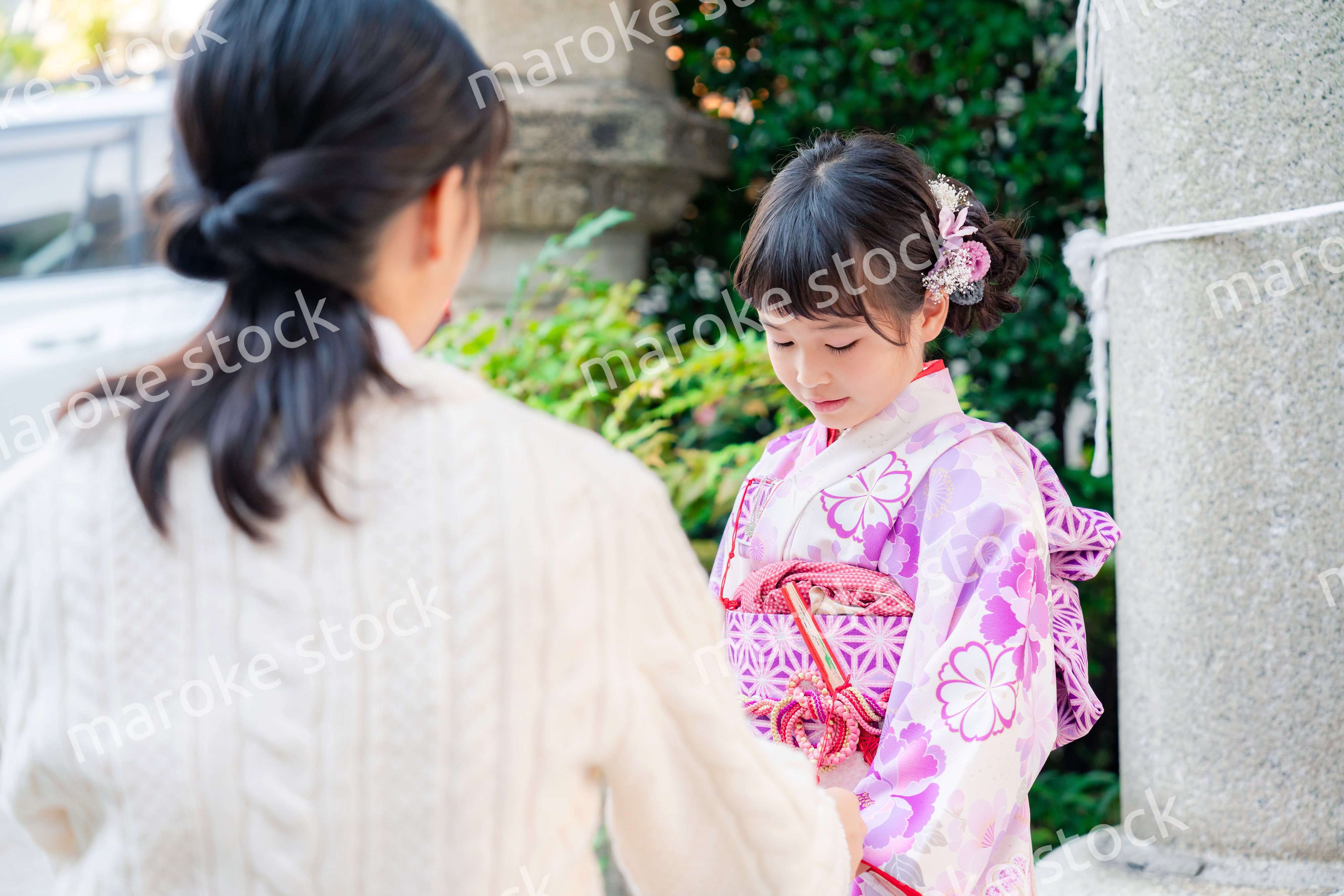 七五三をお祝いする子どもと服を整えるお母さん