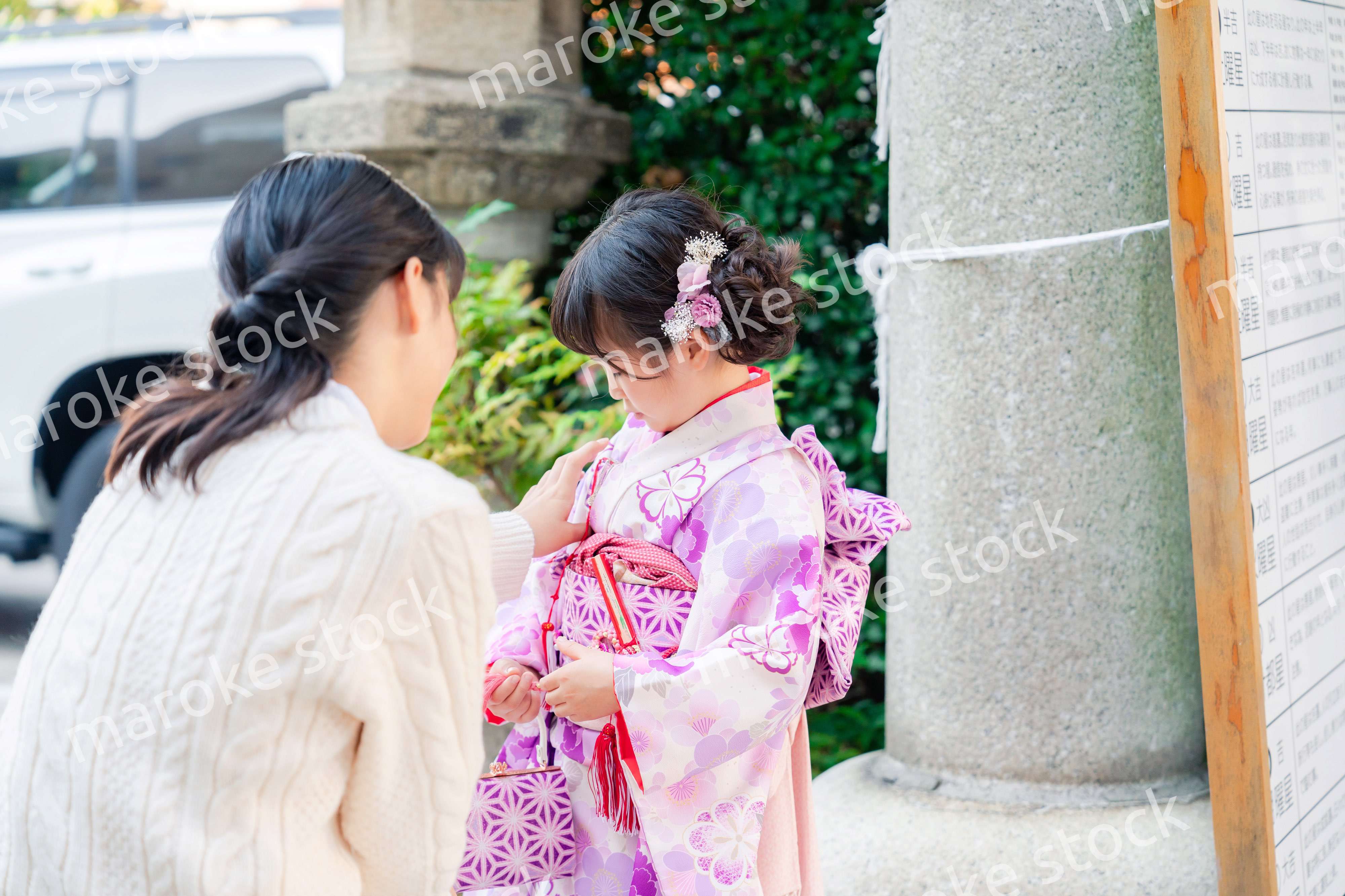 七五三をお祝いする子どもと服を整えるお母さん