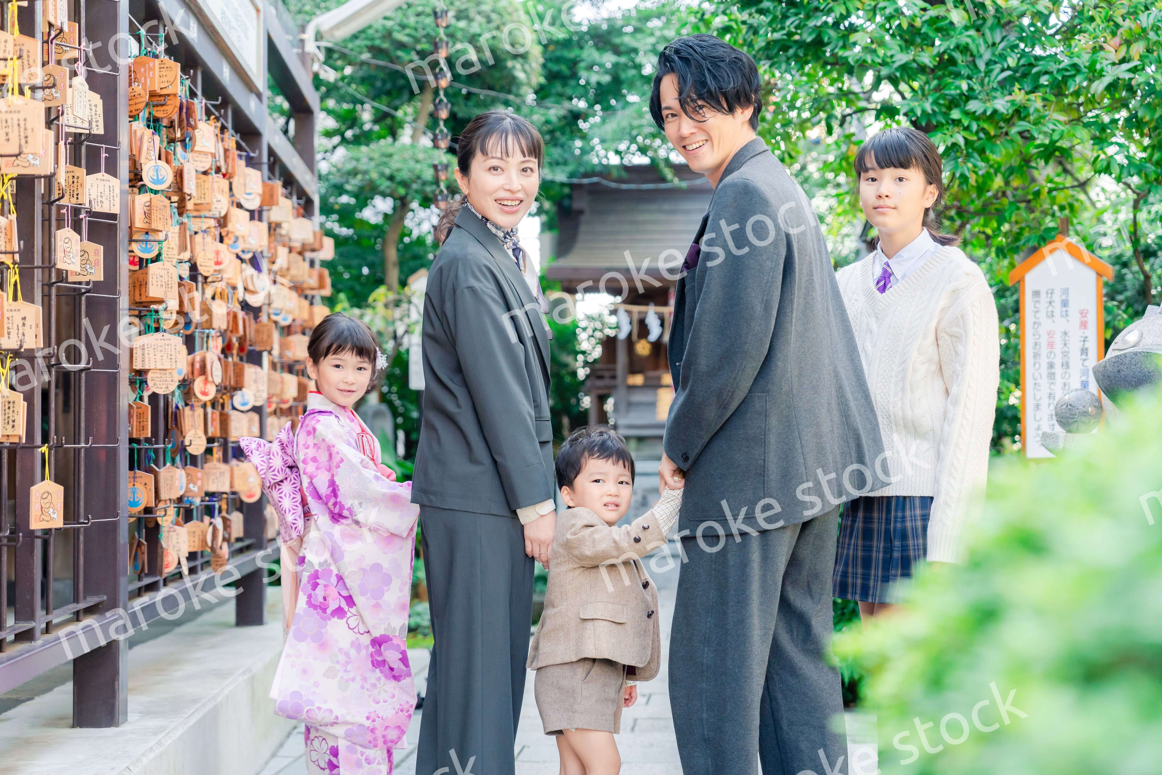 兄弟姉妹揃って神社で七五三のお祝いをする家族