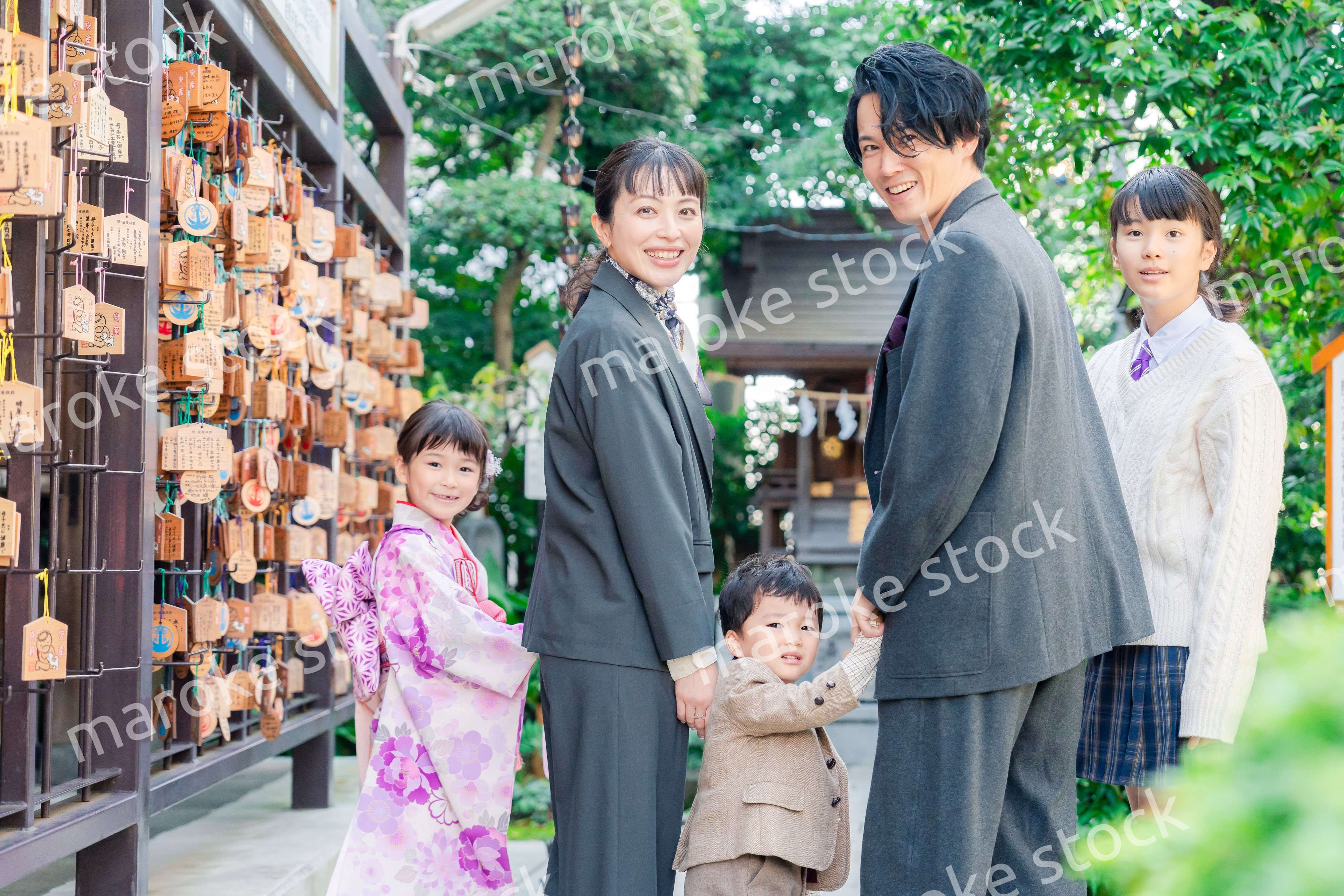 兄弟姉妹揃って神社で七五三のお祝いをする家族