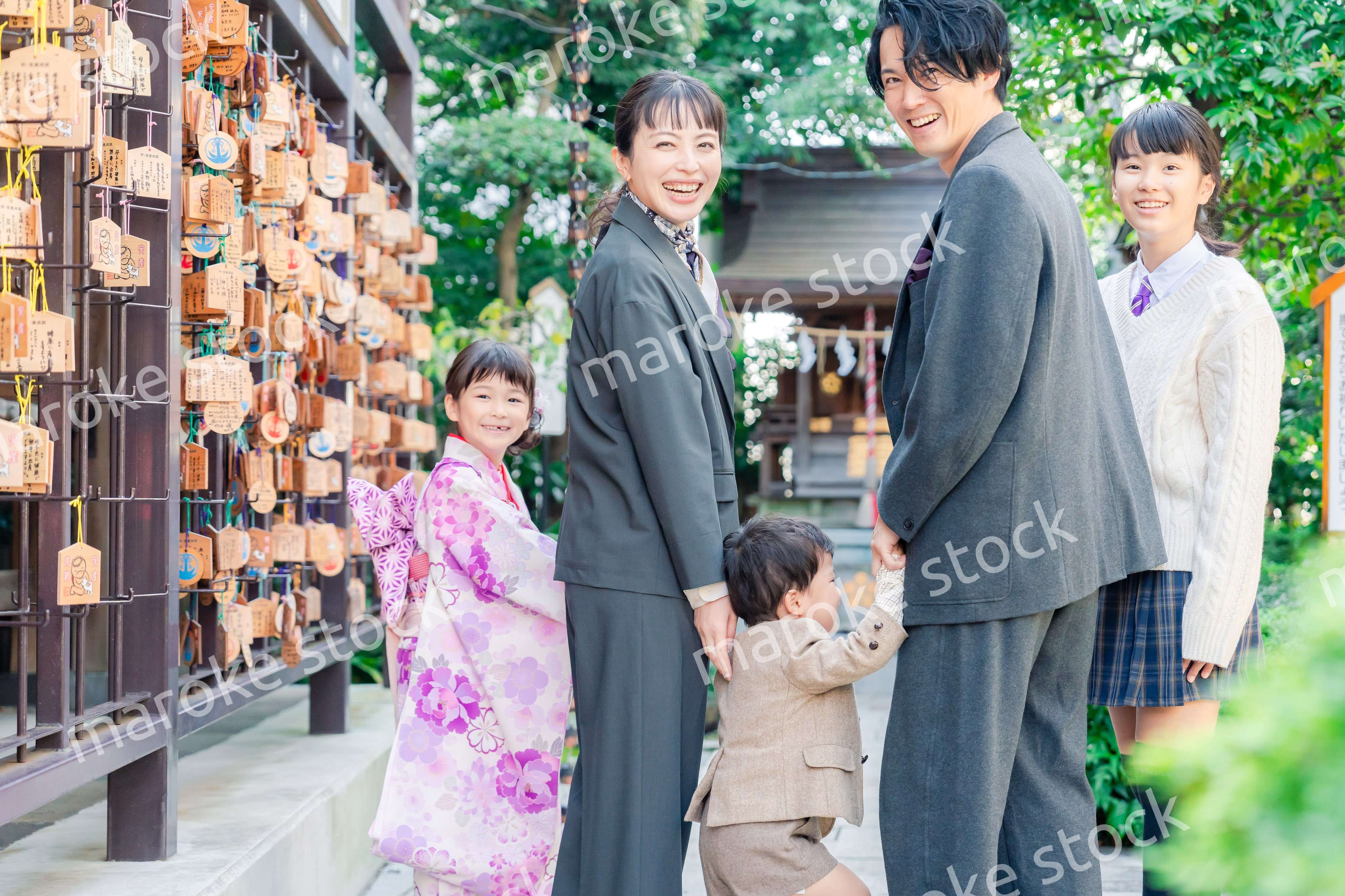 兄弟姉妹揃って神社で七五三のお祝いをする家族