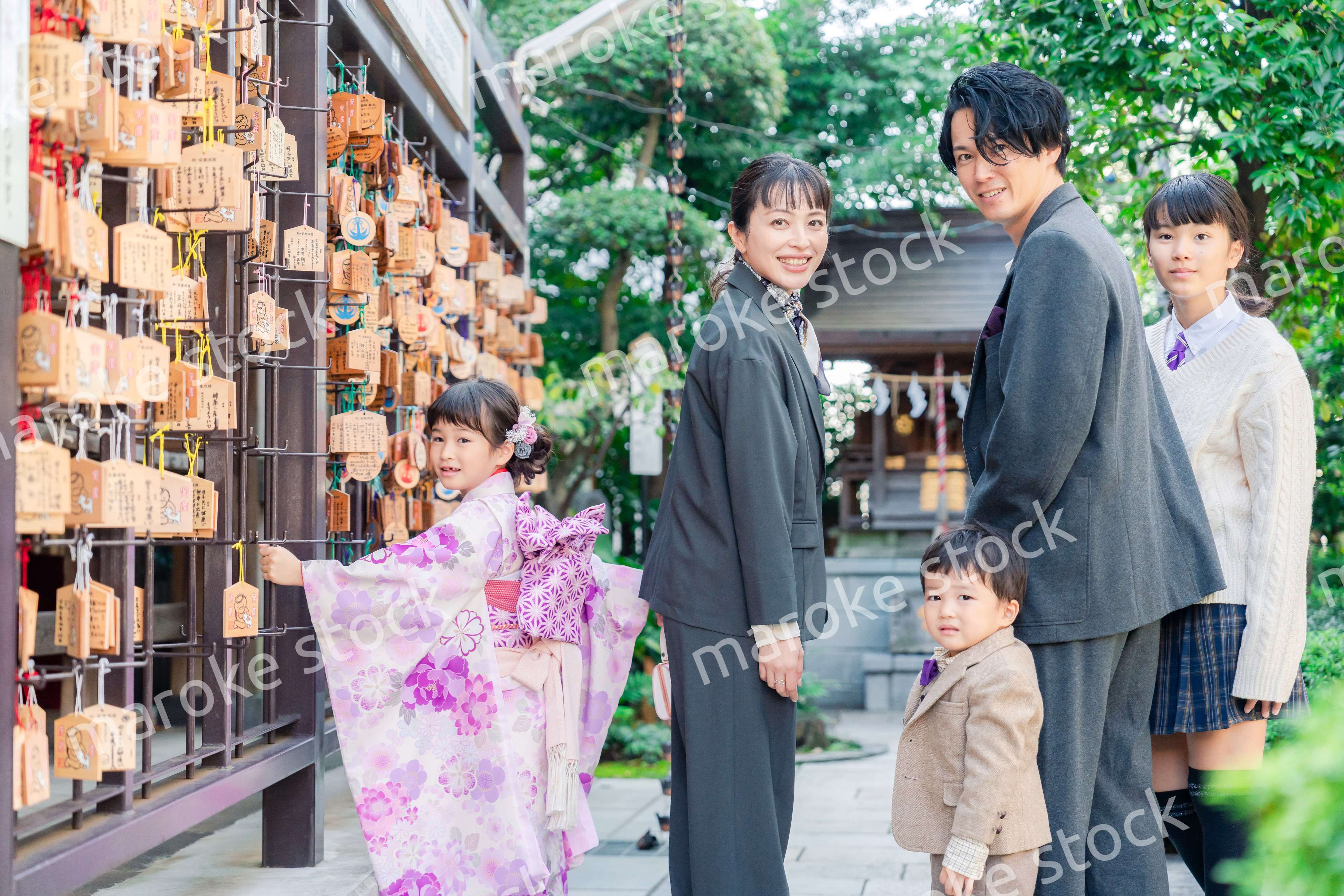 兄弟姉妹揃って神社で七五三のお祝いをする家族
