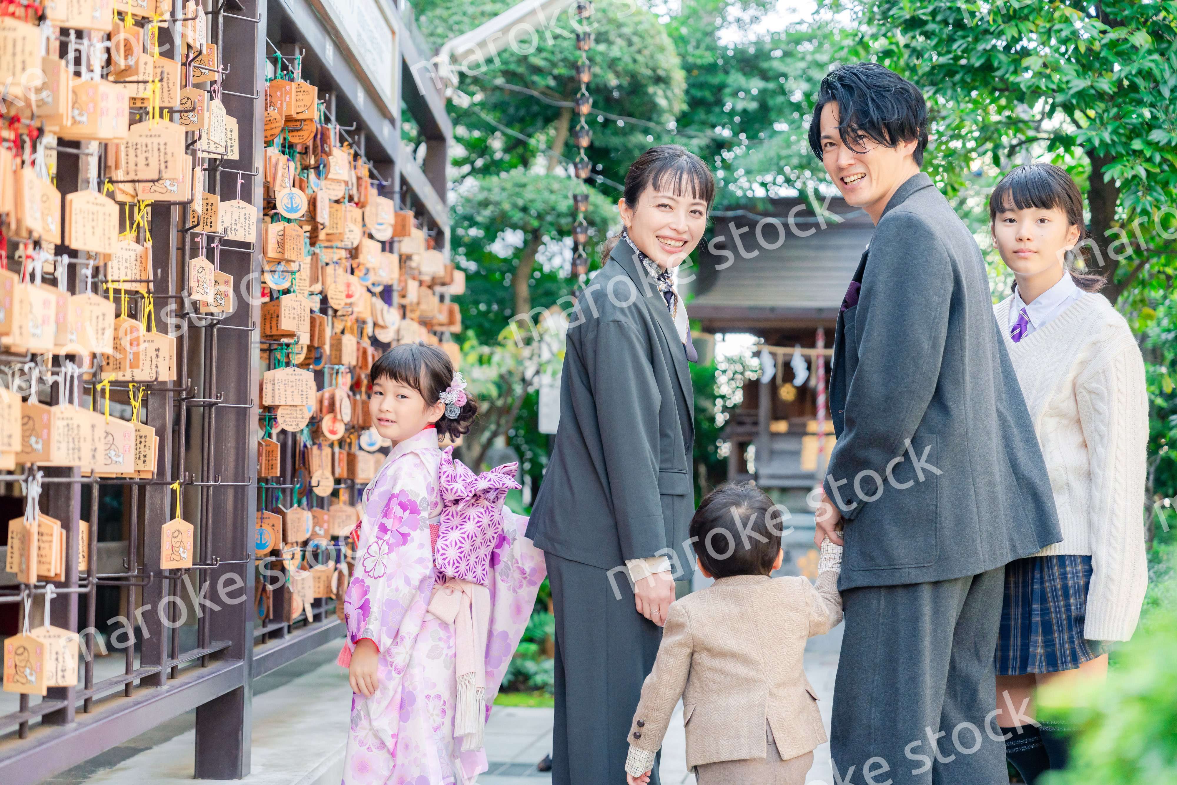 兄弟姉妹揃って神社で七五三のお祝いをする家族
