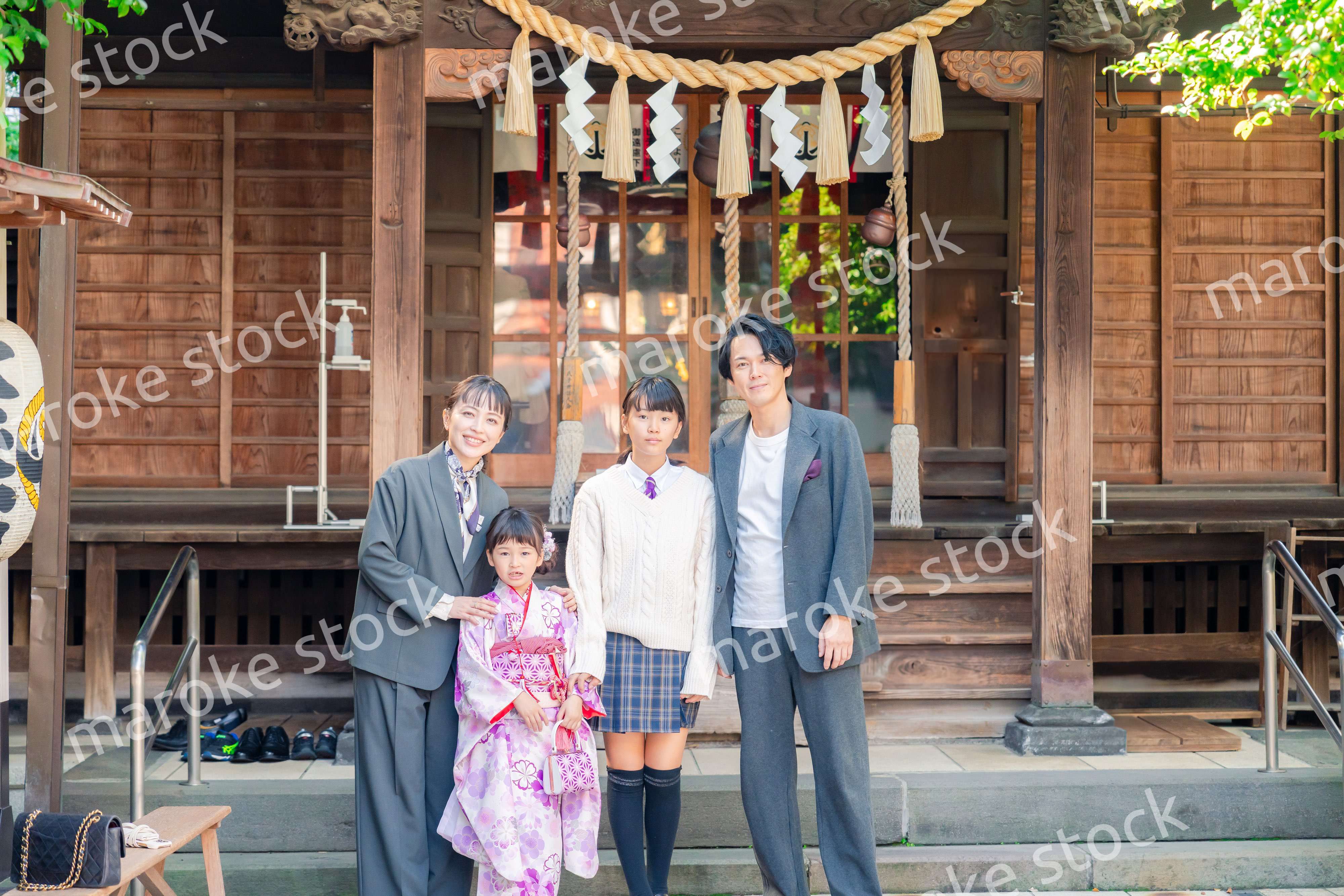 神社で七五三のお祝いをするファミリー