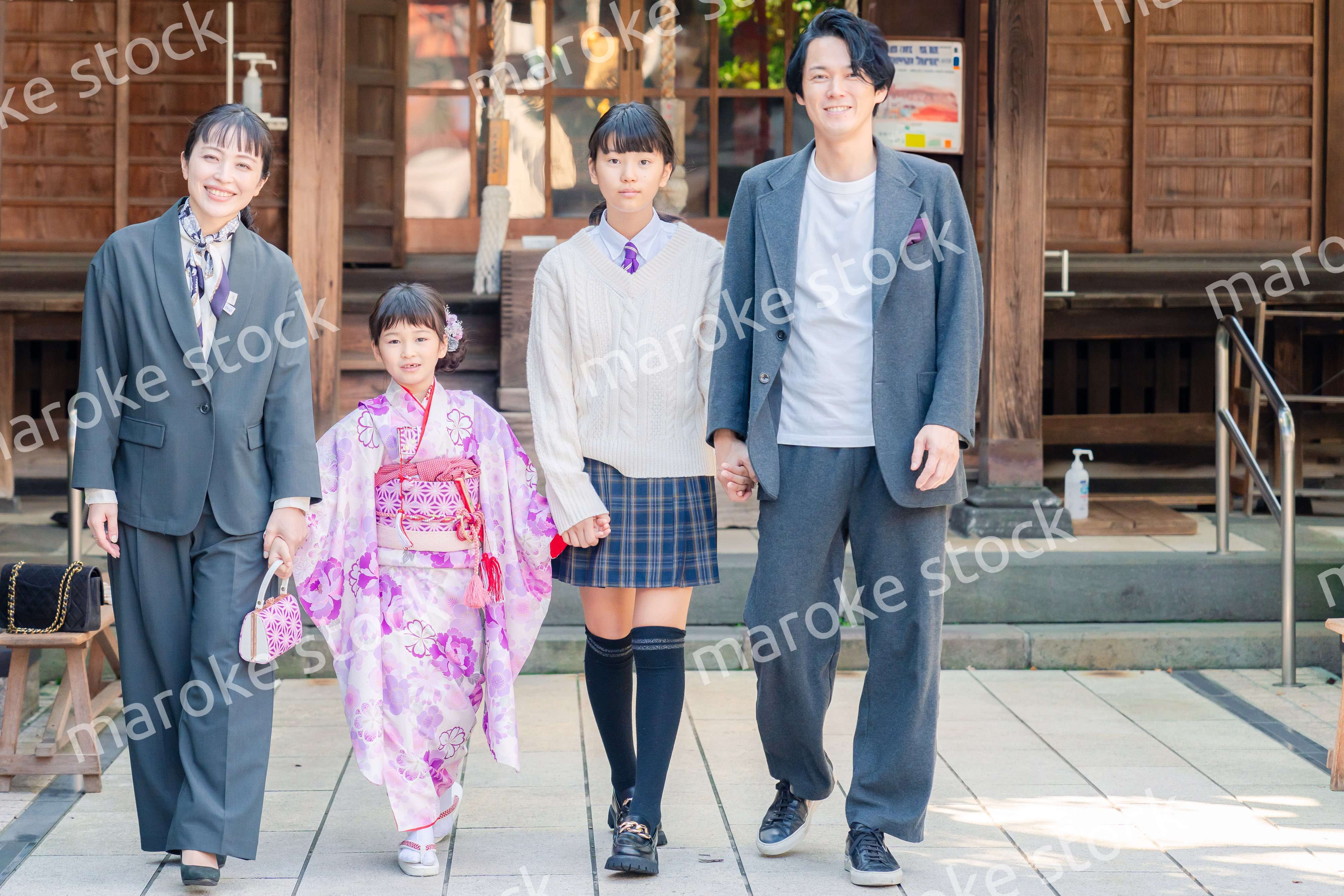 神社で七五三のお祝いをするファミリー