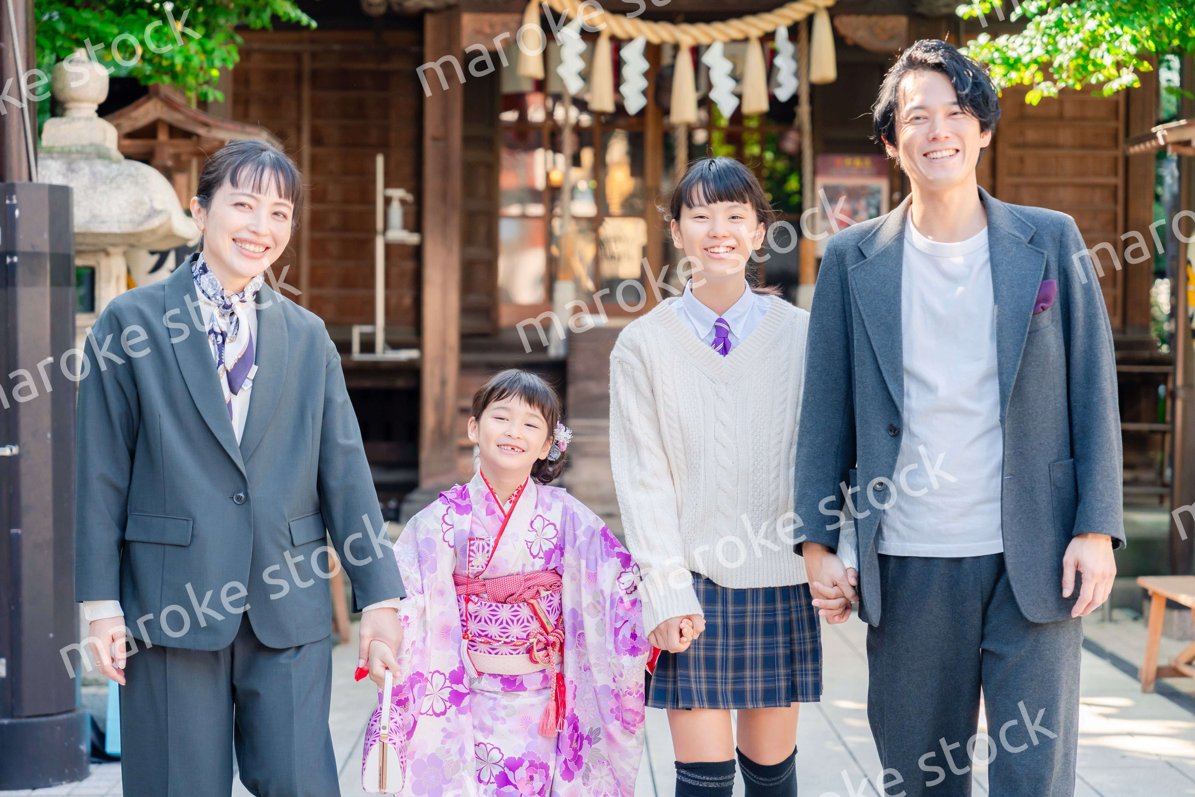 神社で七五三のお祝いをするファミリー