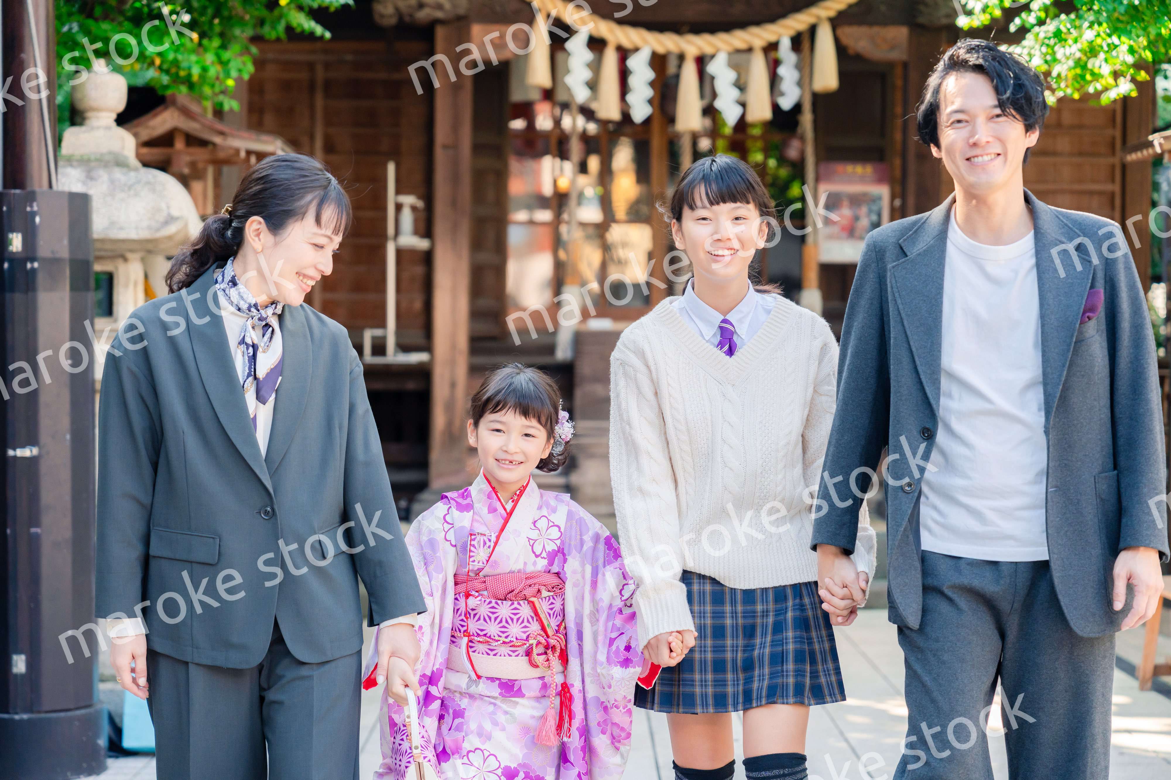 神社で七五三のお祝いをするファミリー