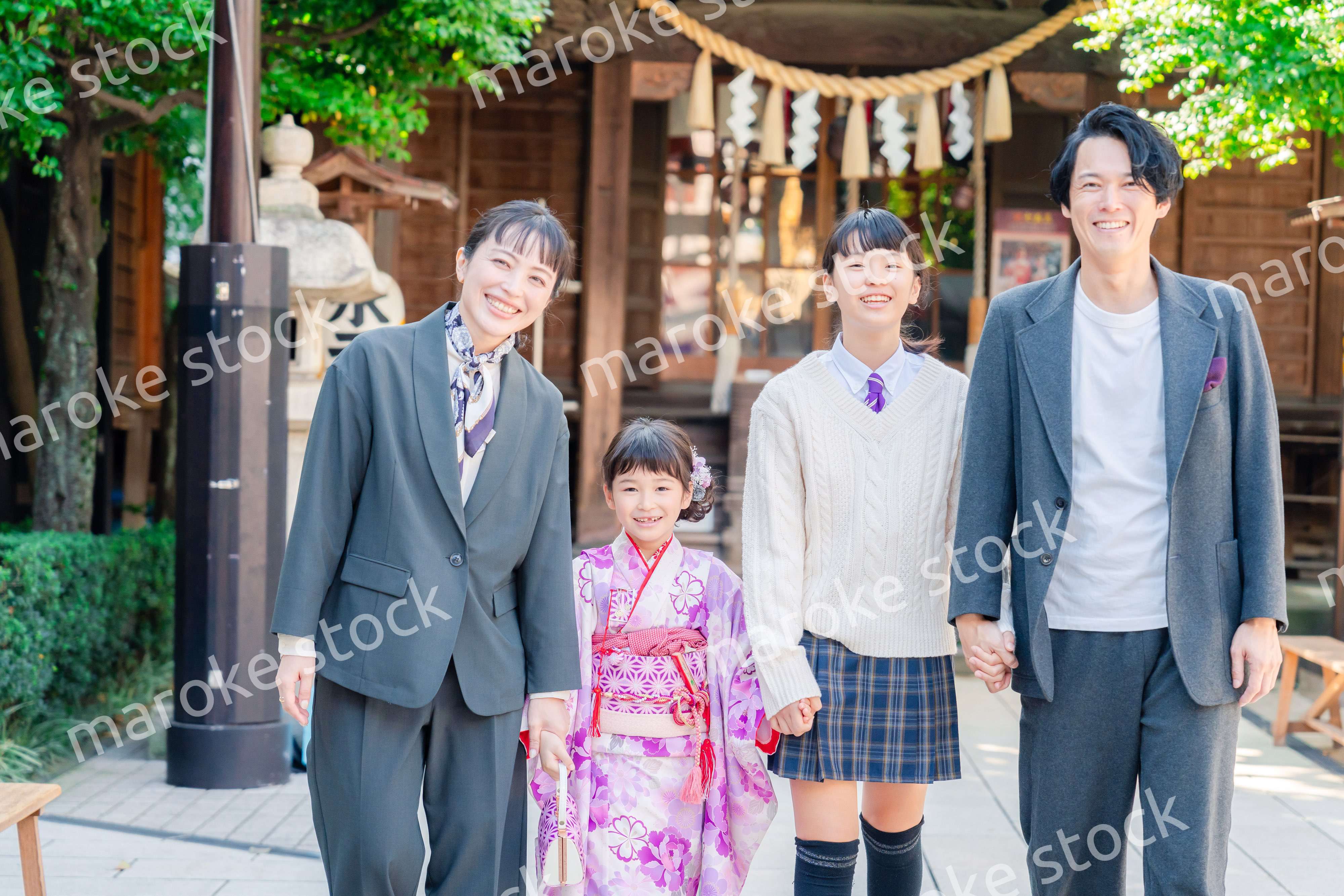 神社で七五三のお祝いをするファミリー