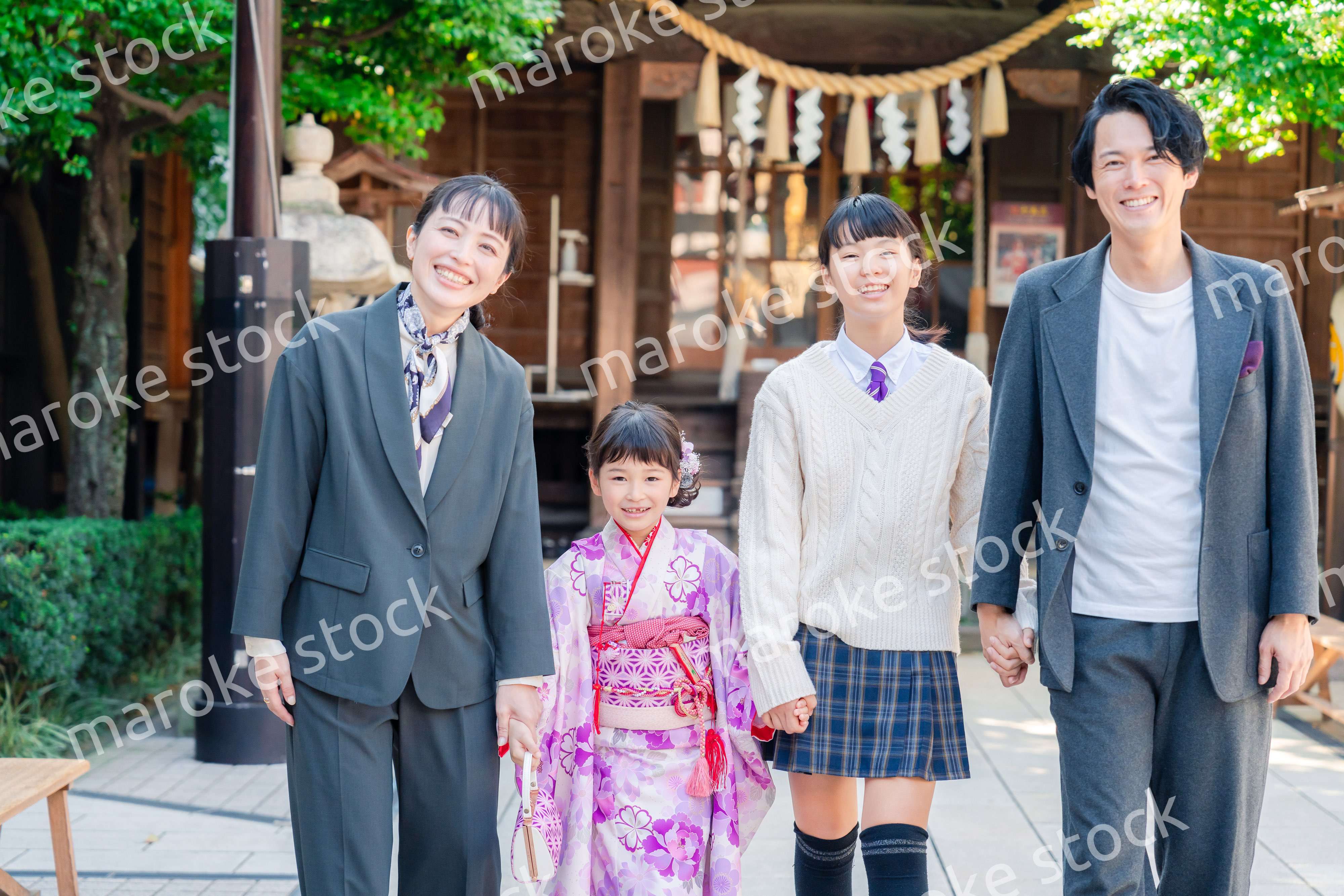 神社で七五三のお祝いをするファミリー