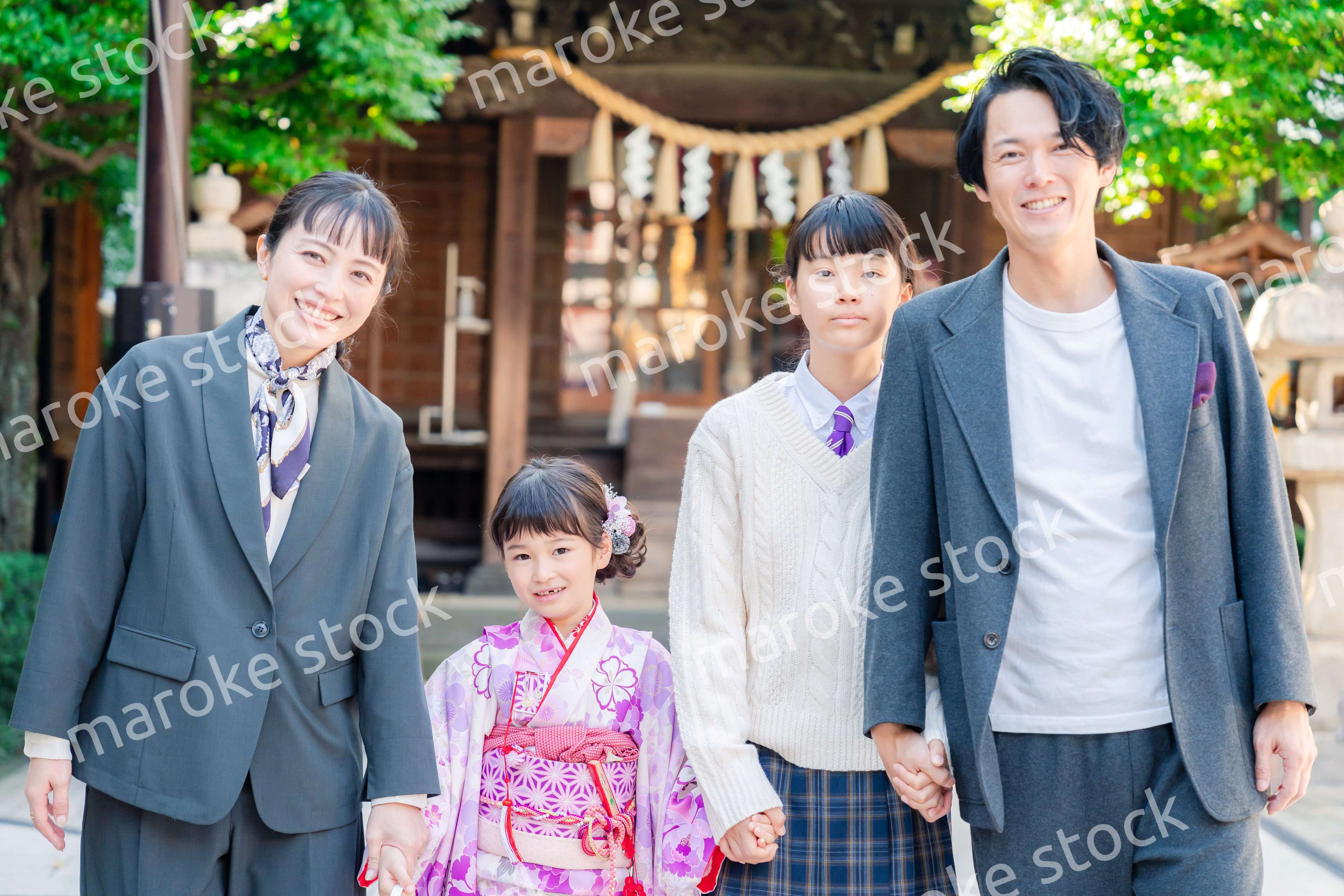 神社で七五三のお祝いをするファミリー