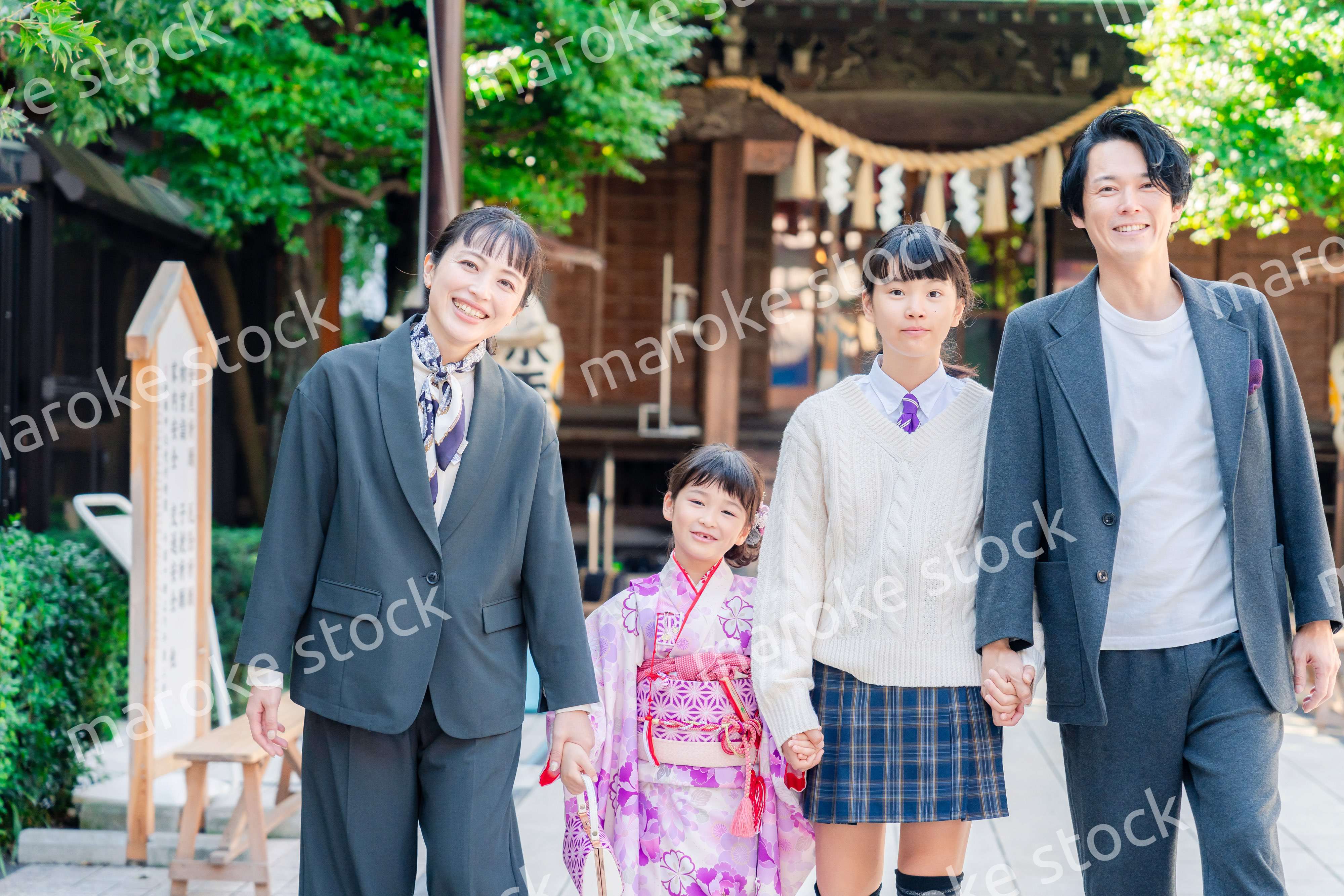 神社で七五三のお祝いをするファミリー