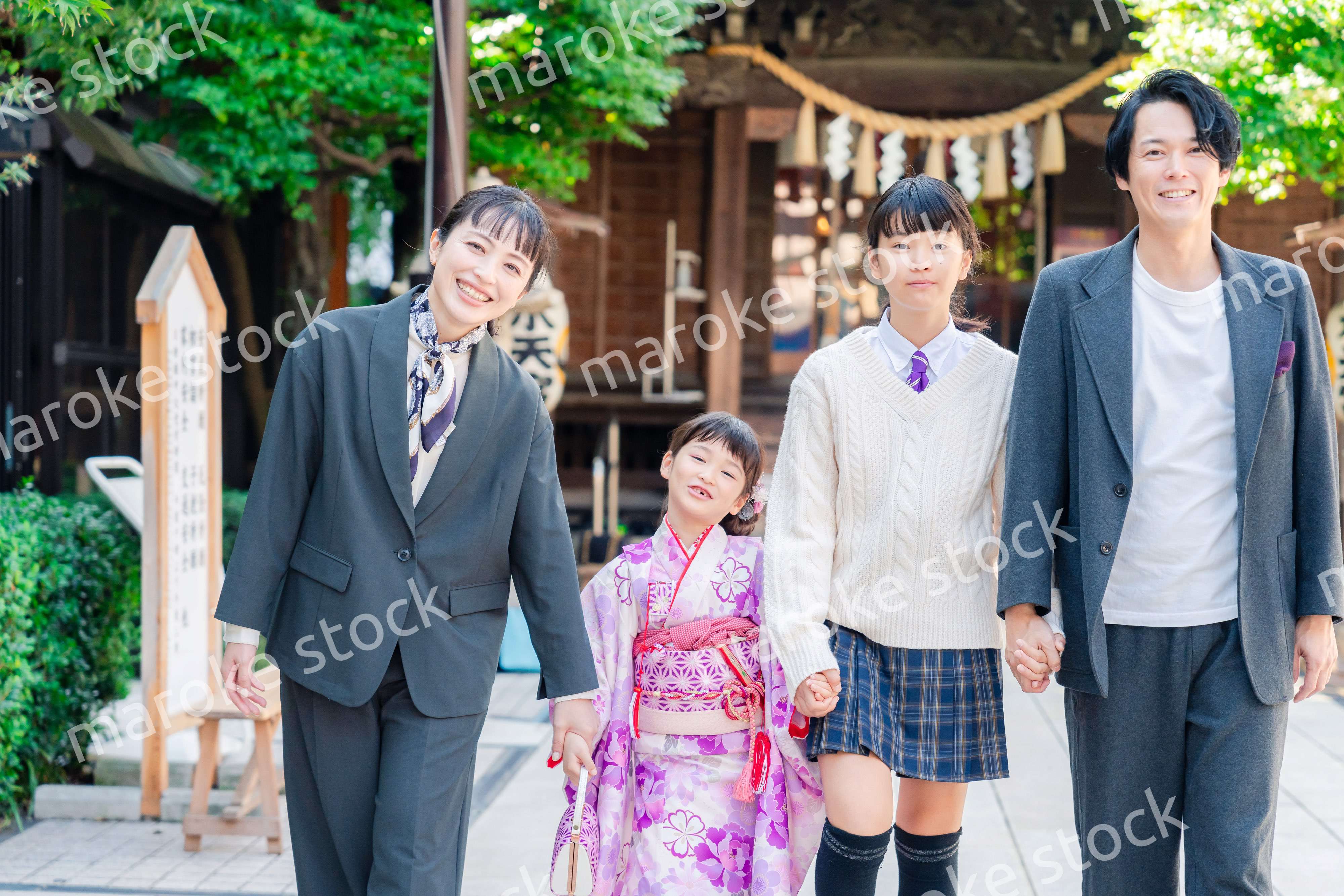 神社で七五三のお祝いをするファミリー