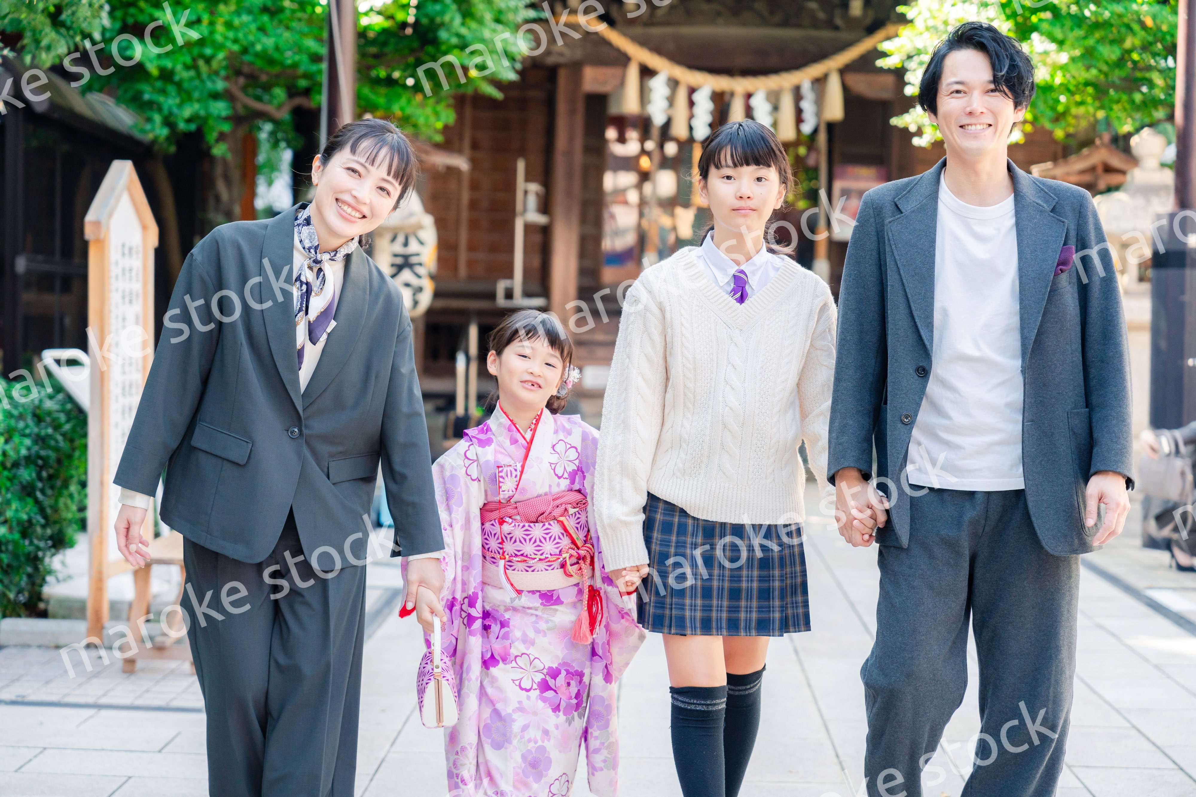 神社で七五三のお祝いをするファミリー