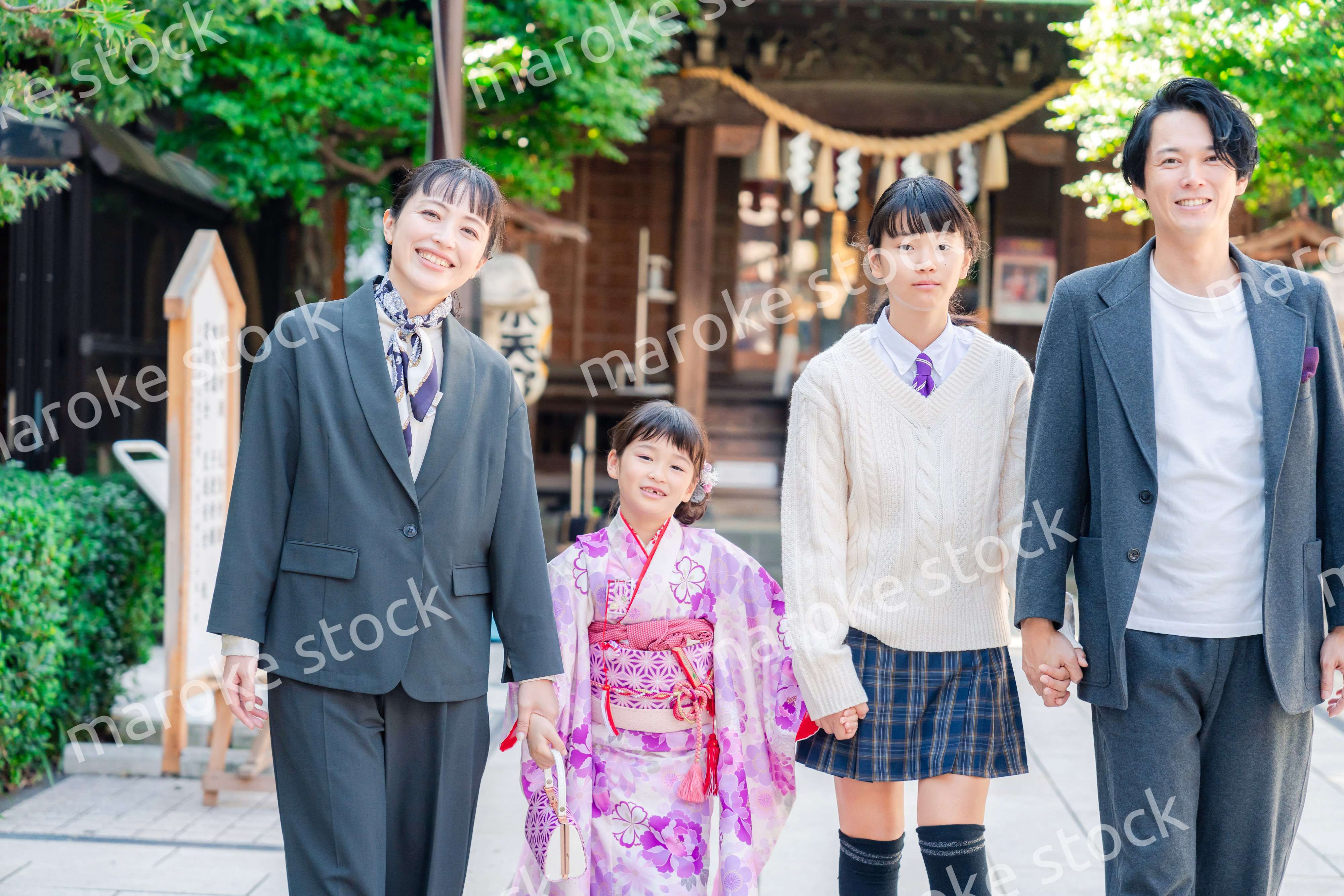 神社で七五三のお祝いをするファミリー