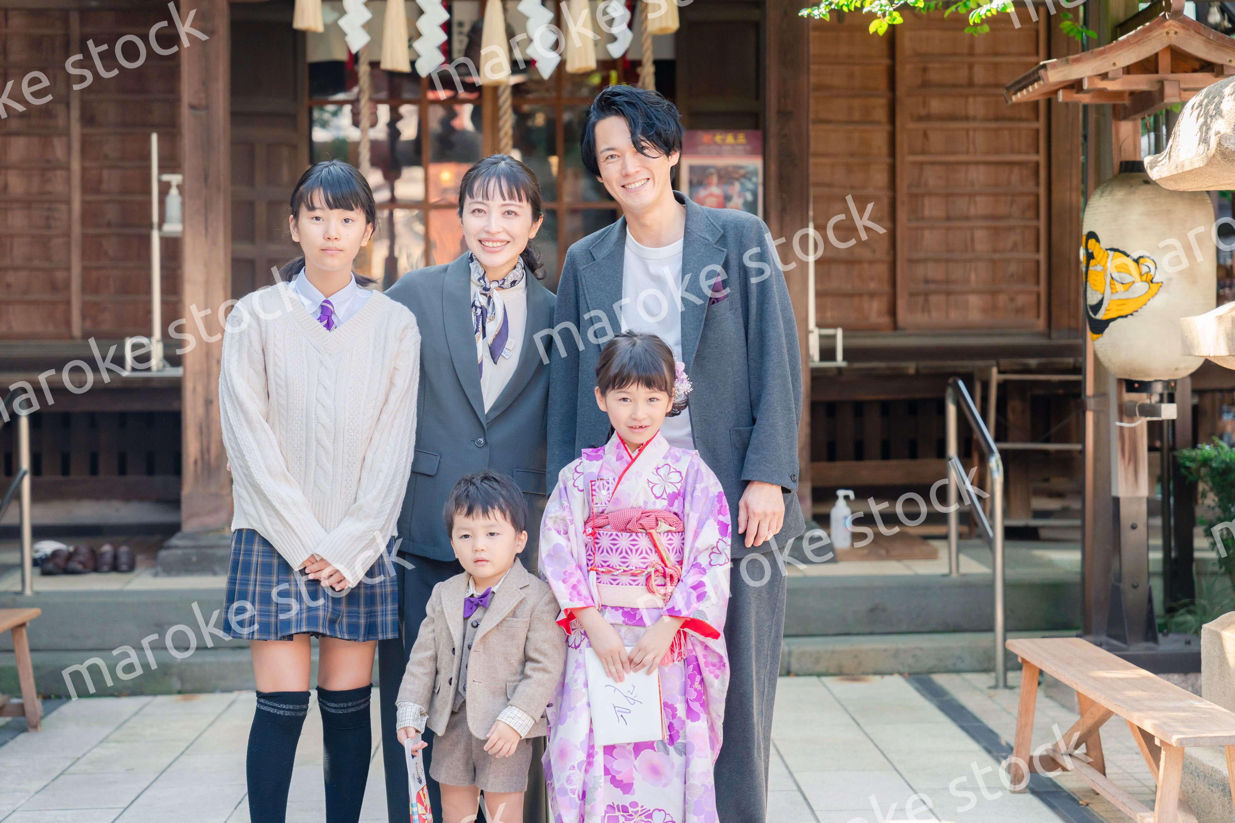 兄弟姉妹揃って神社で七五三のお祝いをする家族
