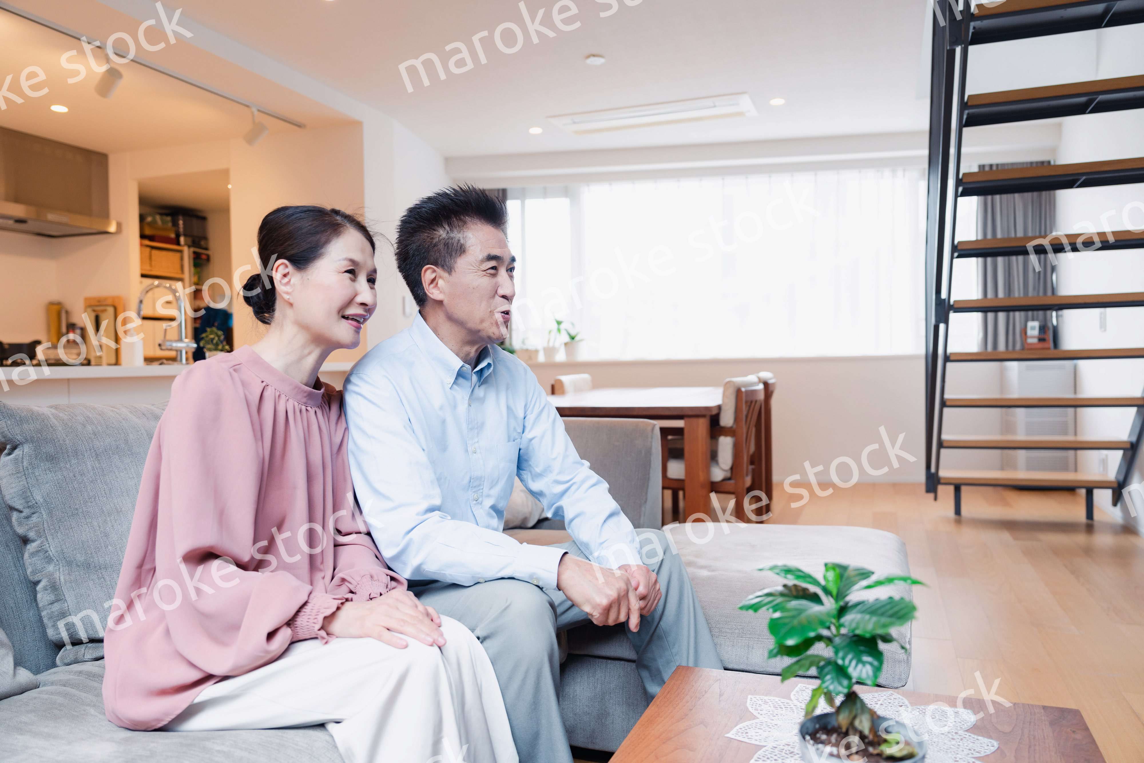 家でテレビを見るシニアの夫婦