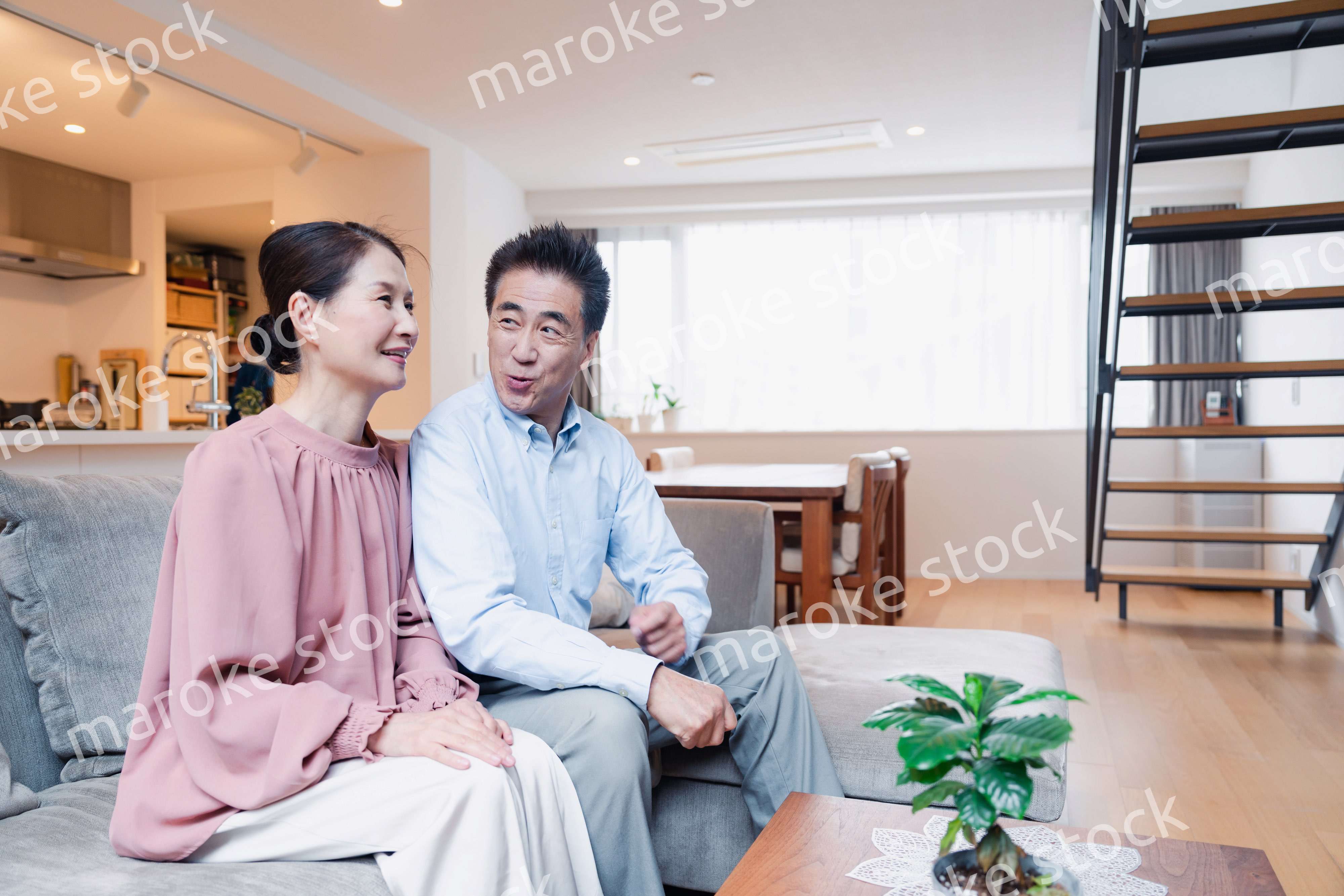 家でテレビを見るシニアの夫婦