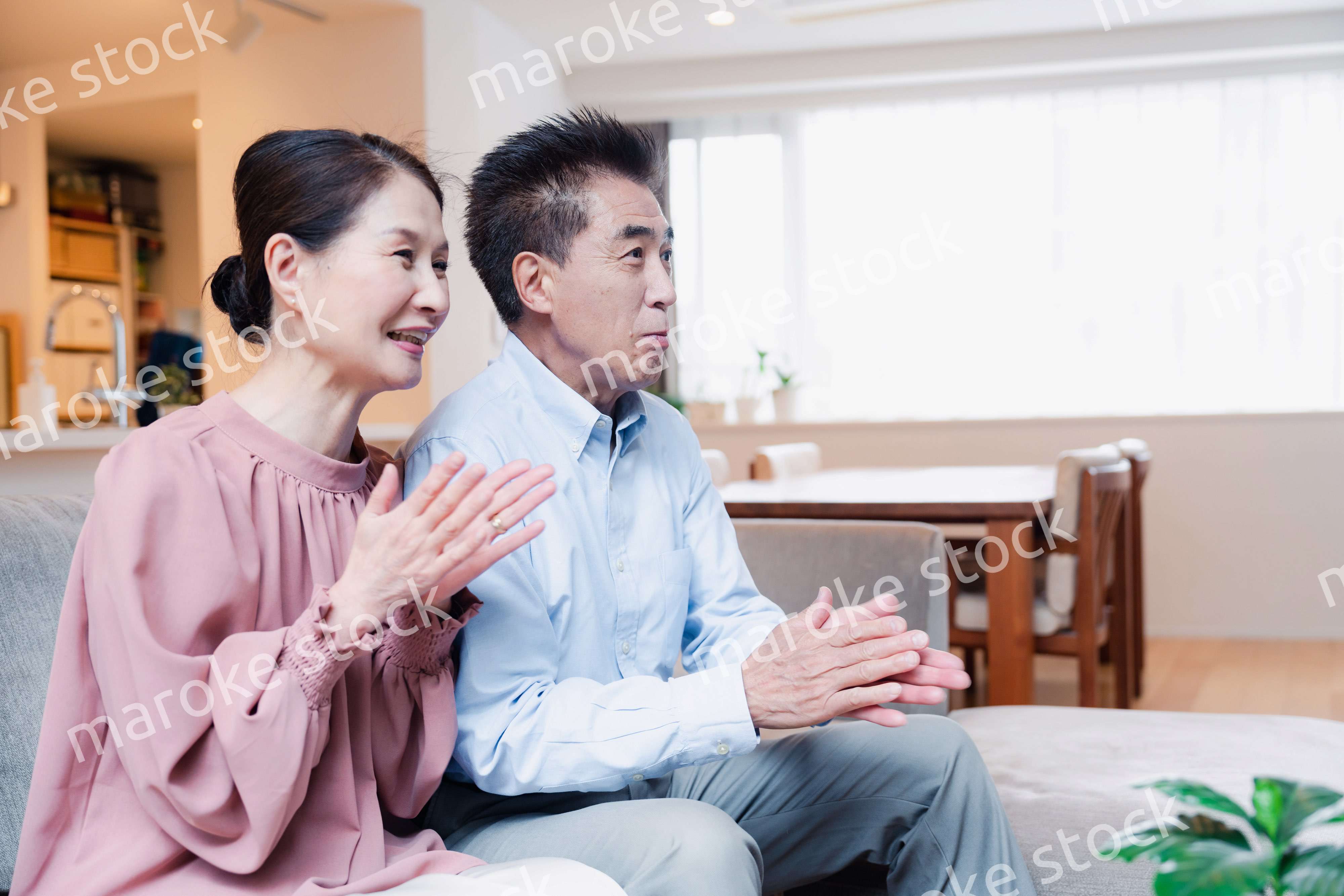 家でテレビを見るシニアの夫婦