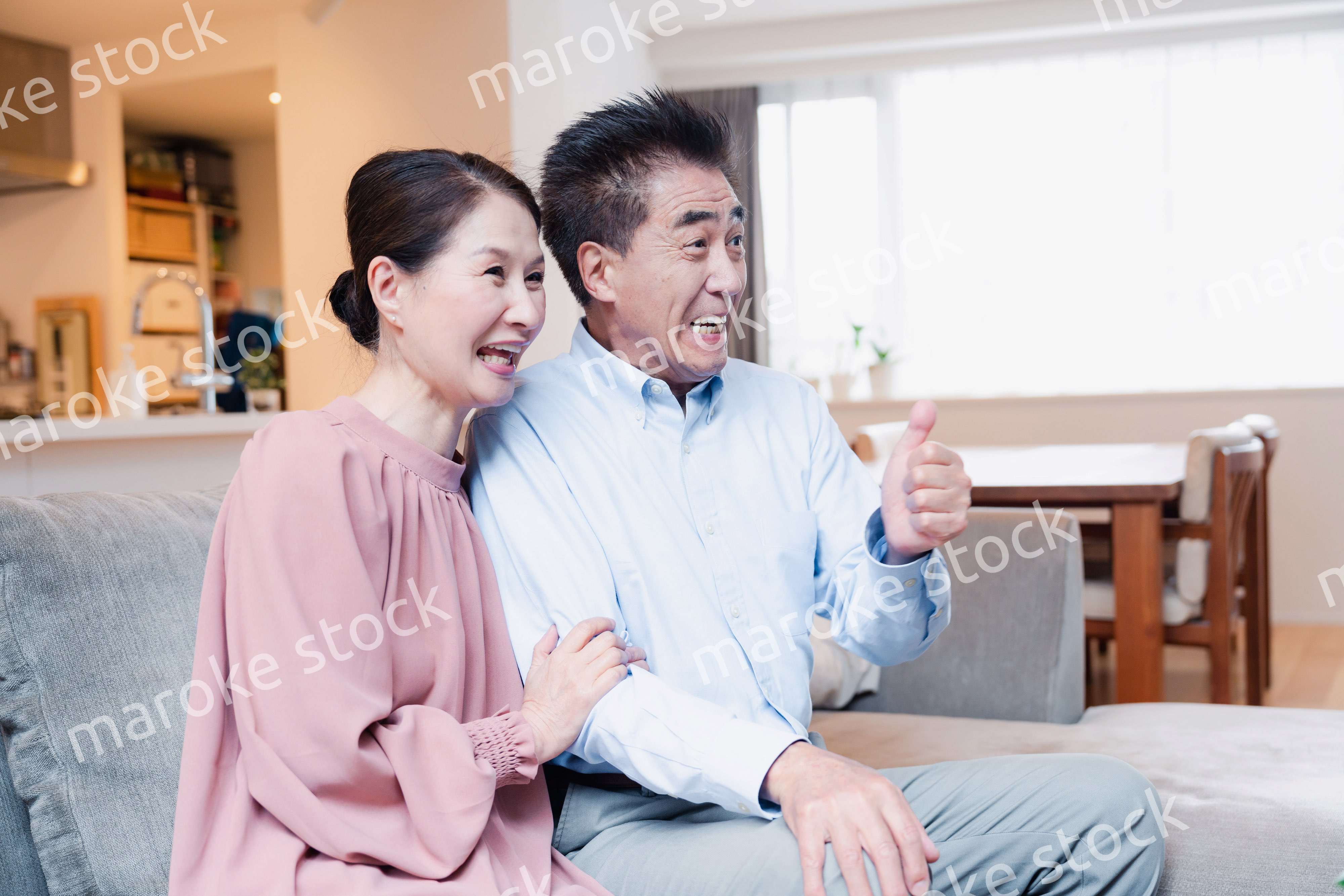 家でテレビを見るシニアの夫婦