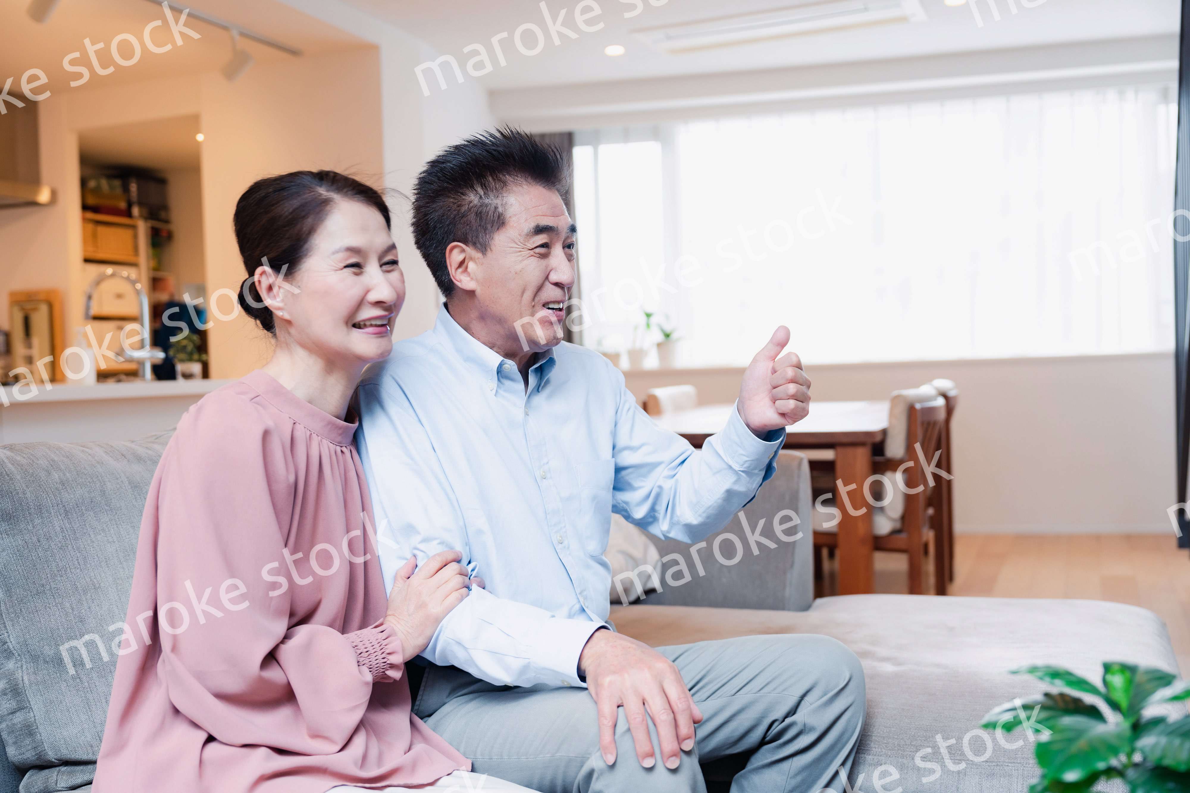家でテレビを見るシニアの夫婦