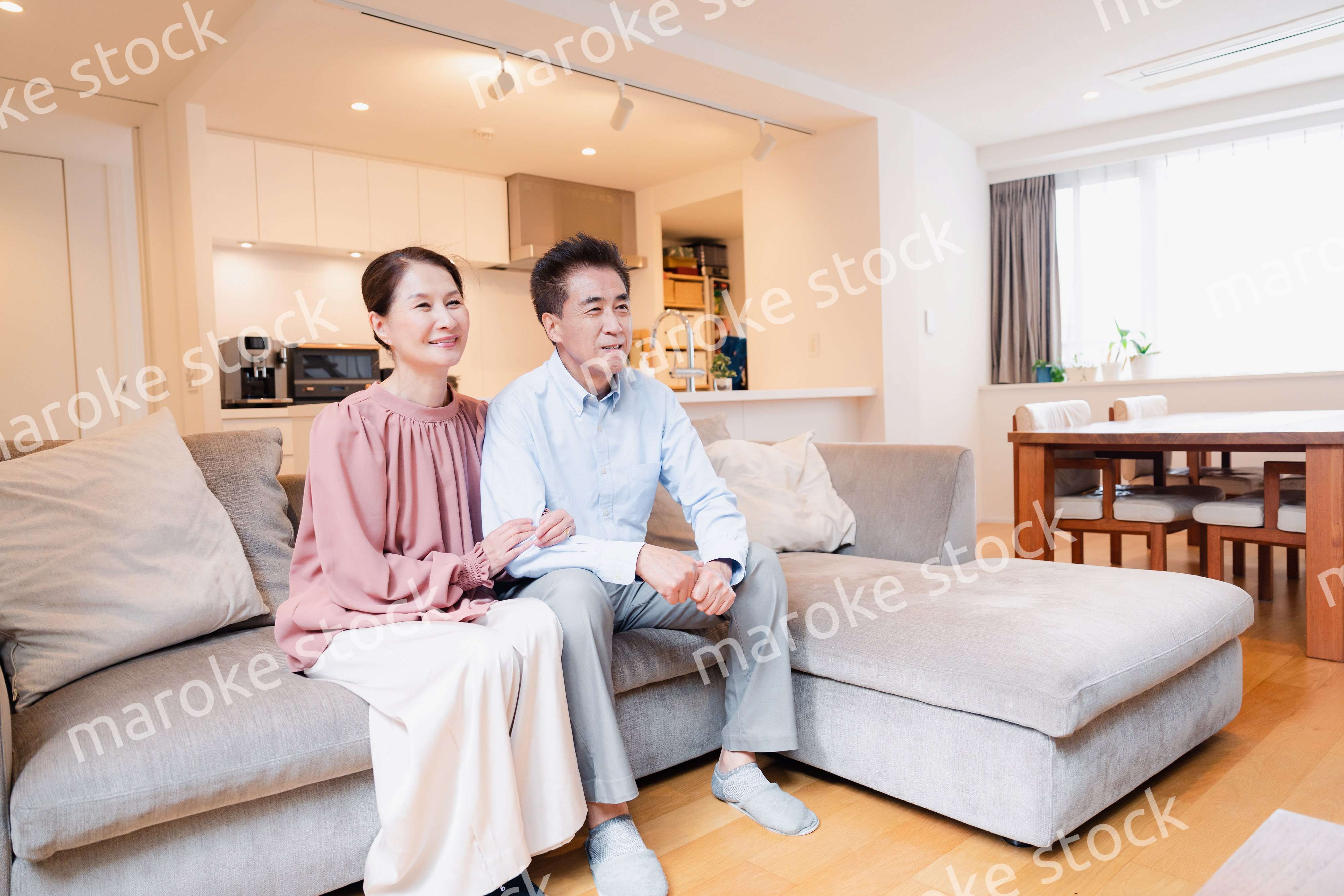 家でテレビを見るシニアの夫婦