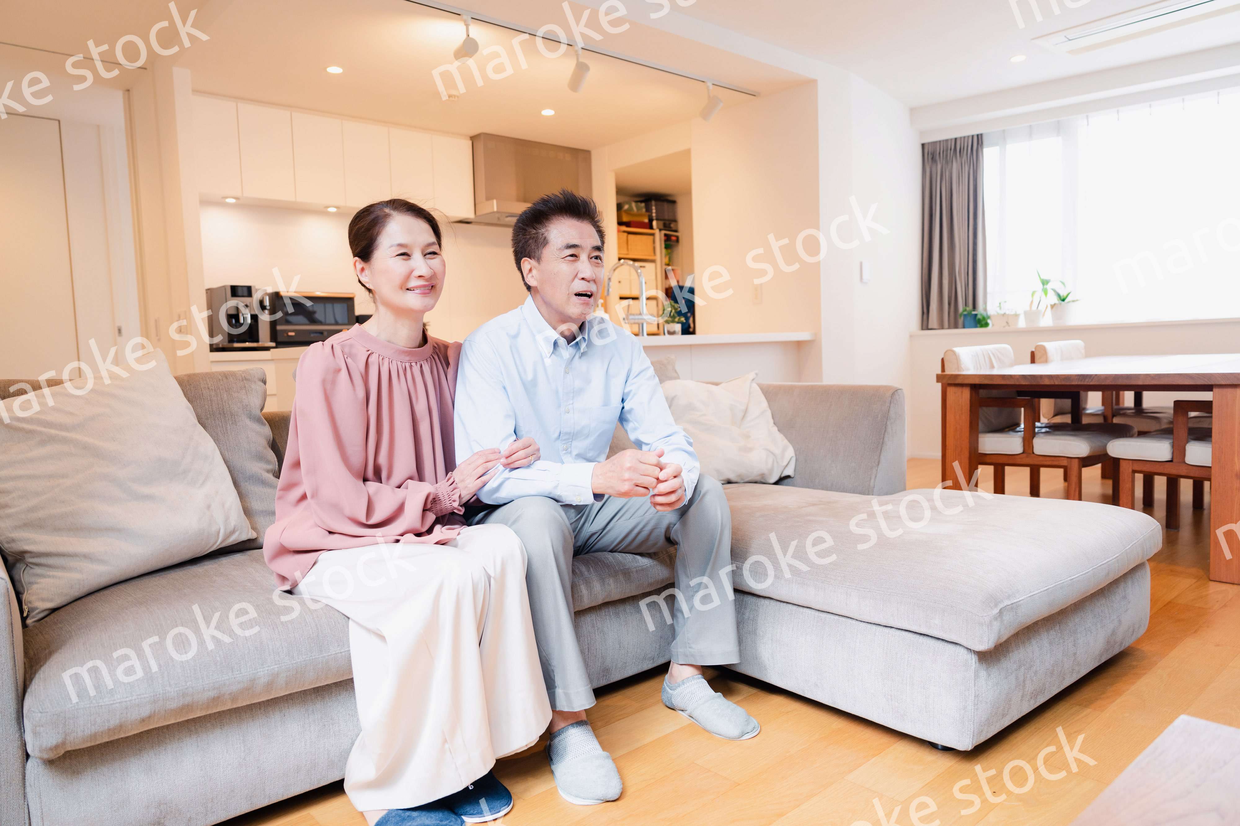 家でテレビを見るシニアの夫婦