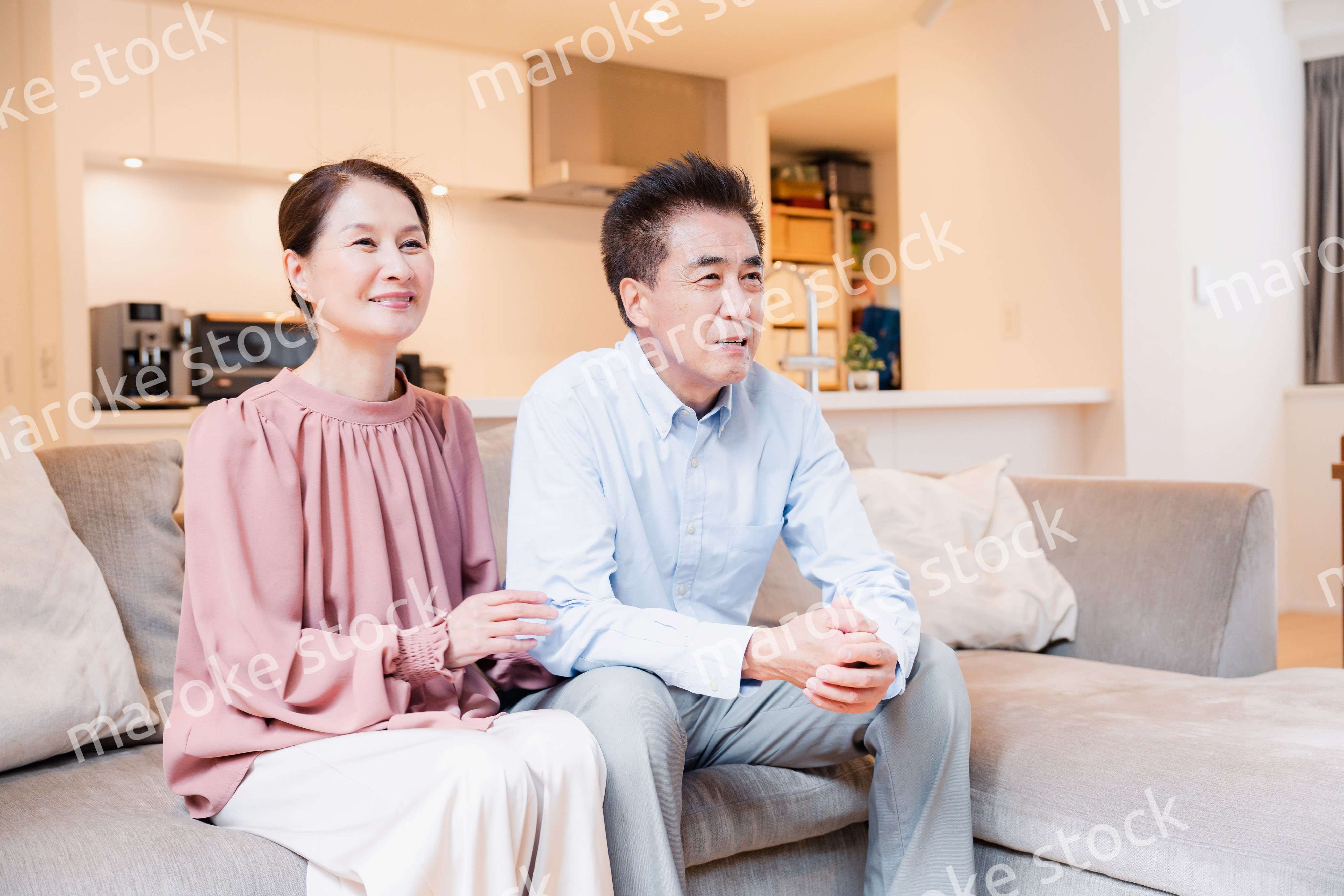 家でテレビを見るシニアの夫婦